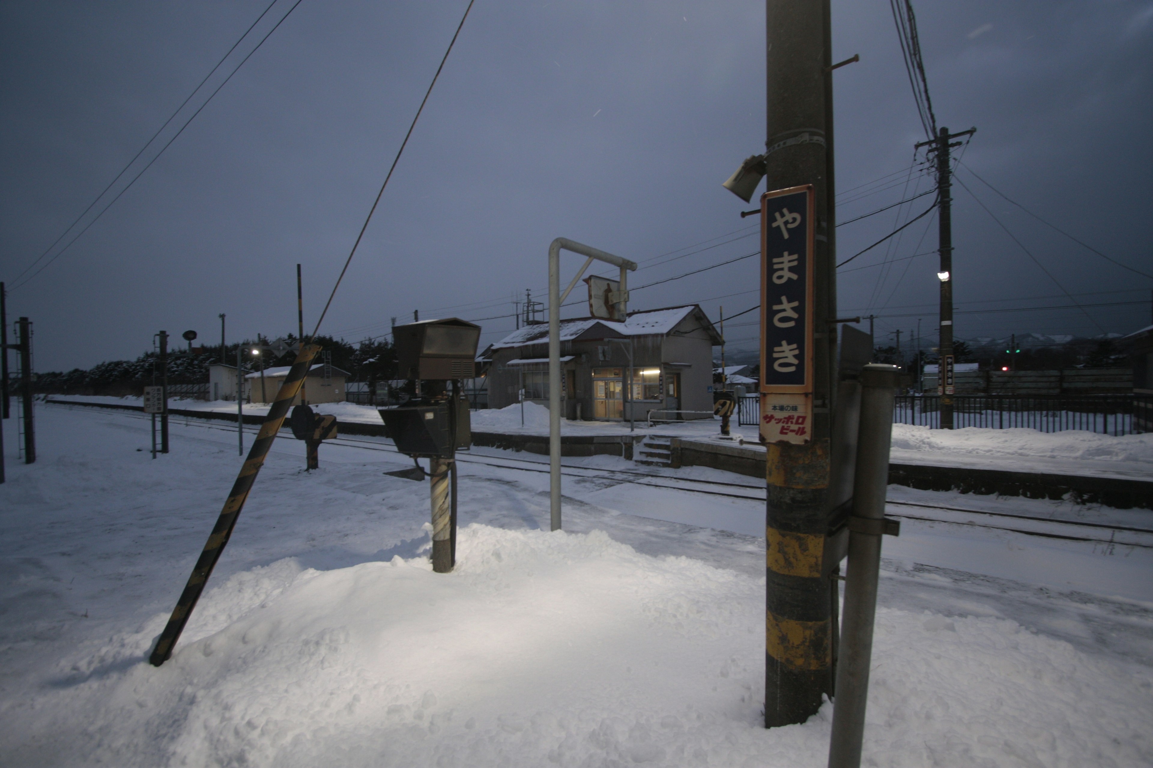 Schneebedeckte Bahnhofsituation in der Dämmerung mit kalter Atmosphäre