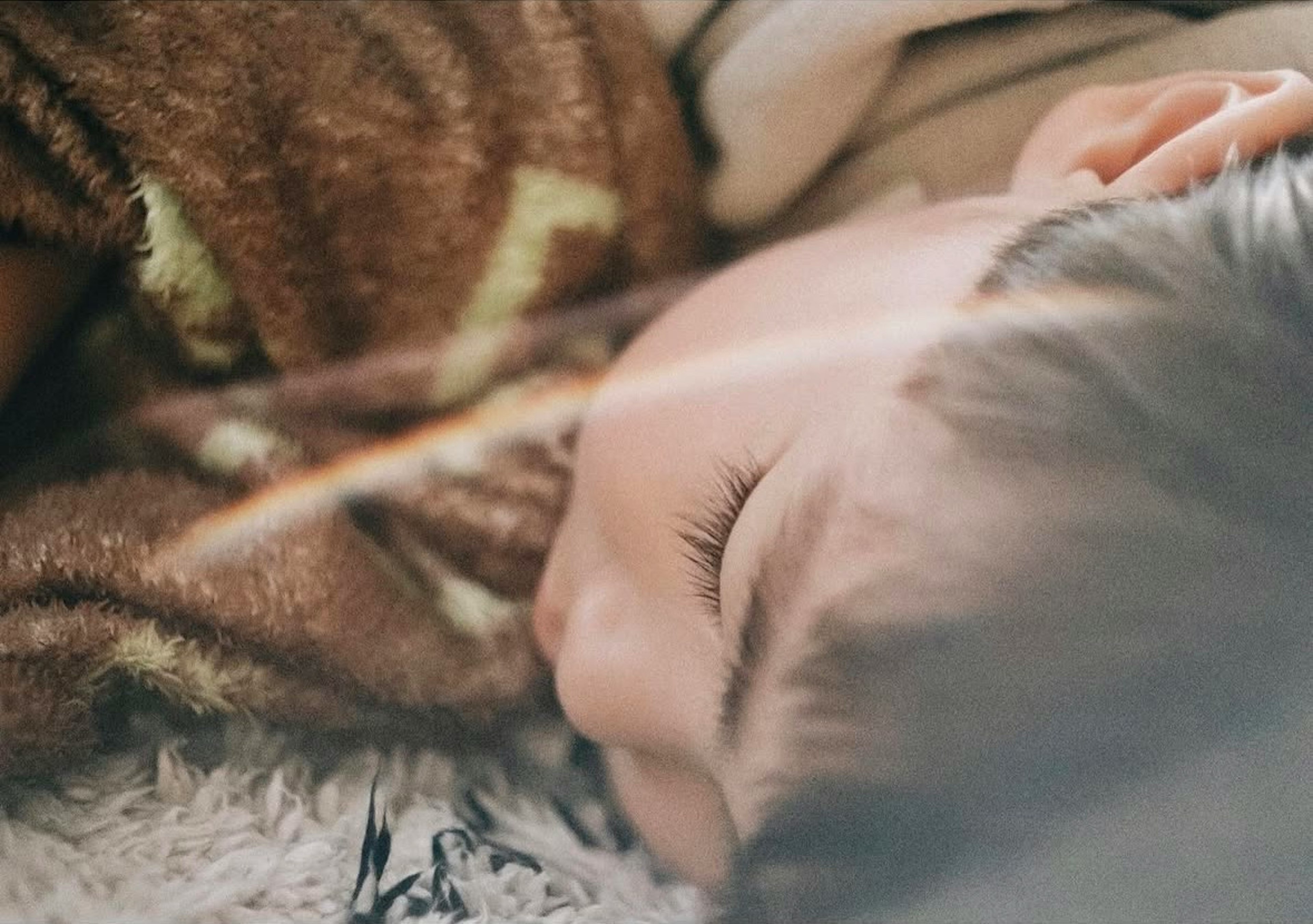 Close-up of a sleeping child wrapped in a blanket