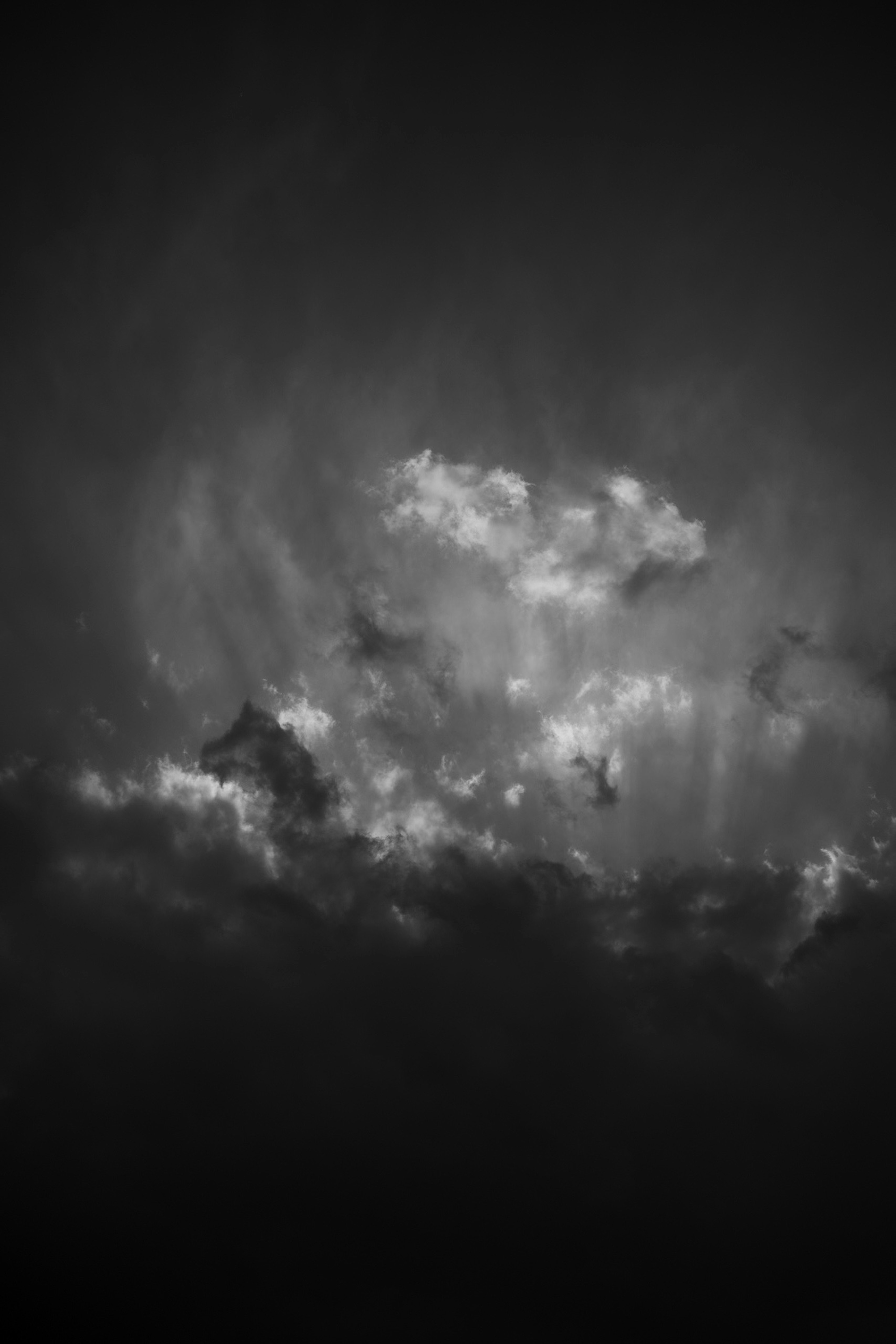 黒と白の雲が浮かぶ空の画像