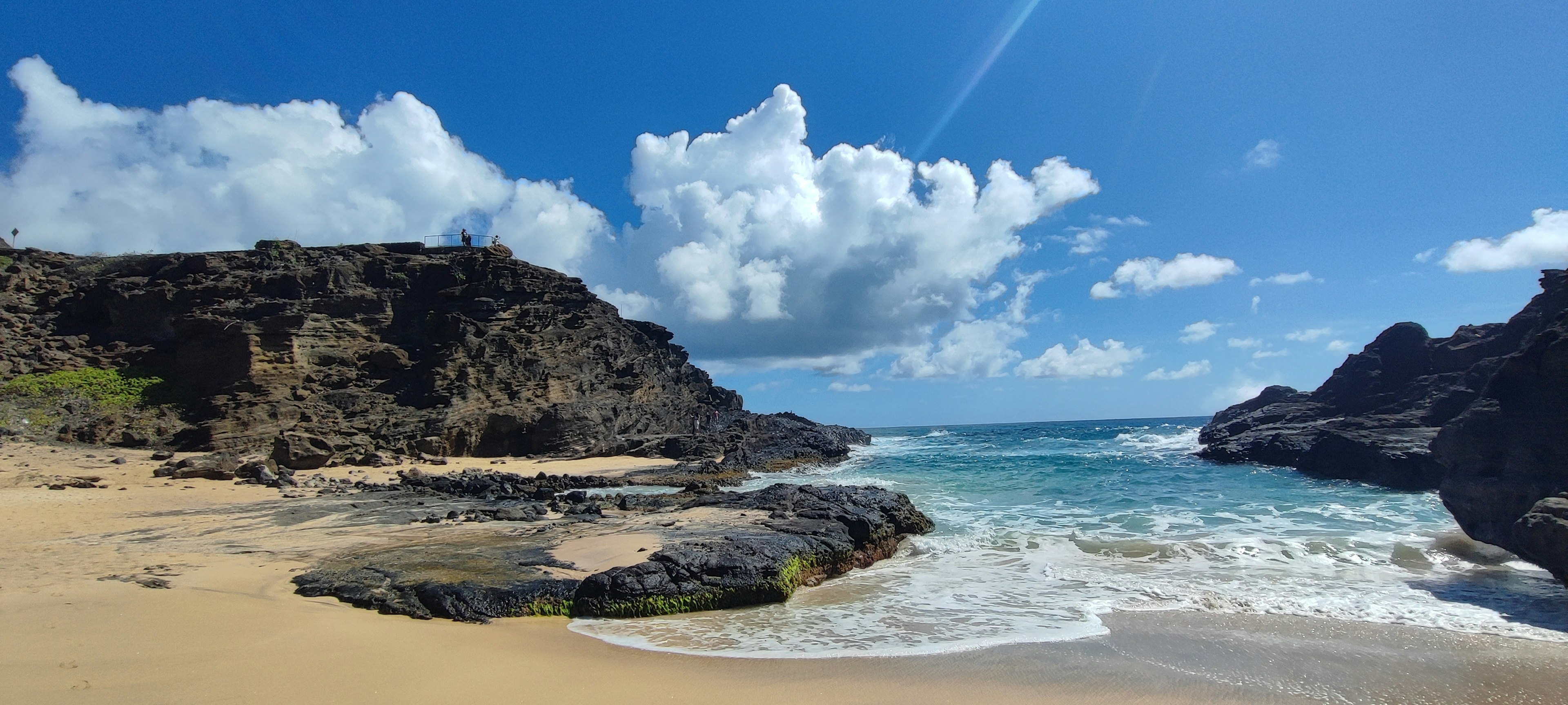 Scène de plage magnifique avec ciel bleu nuages blancs rochers et vagues