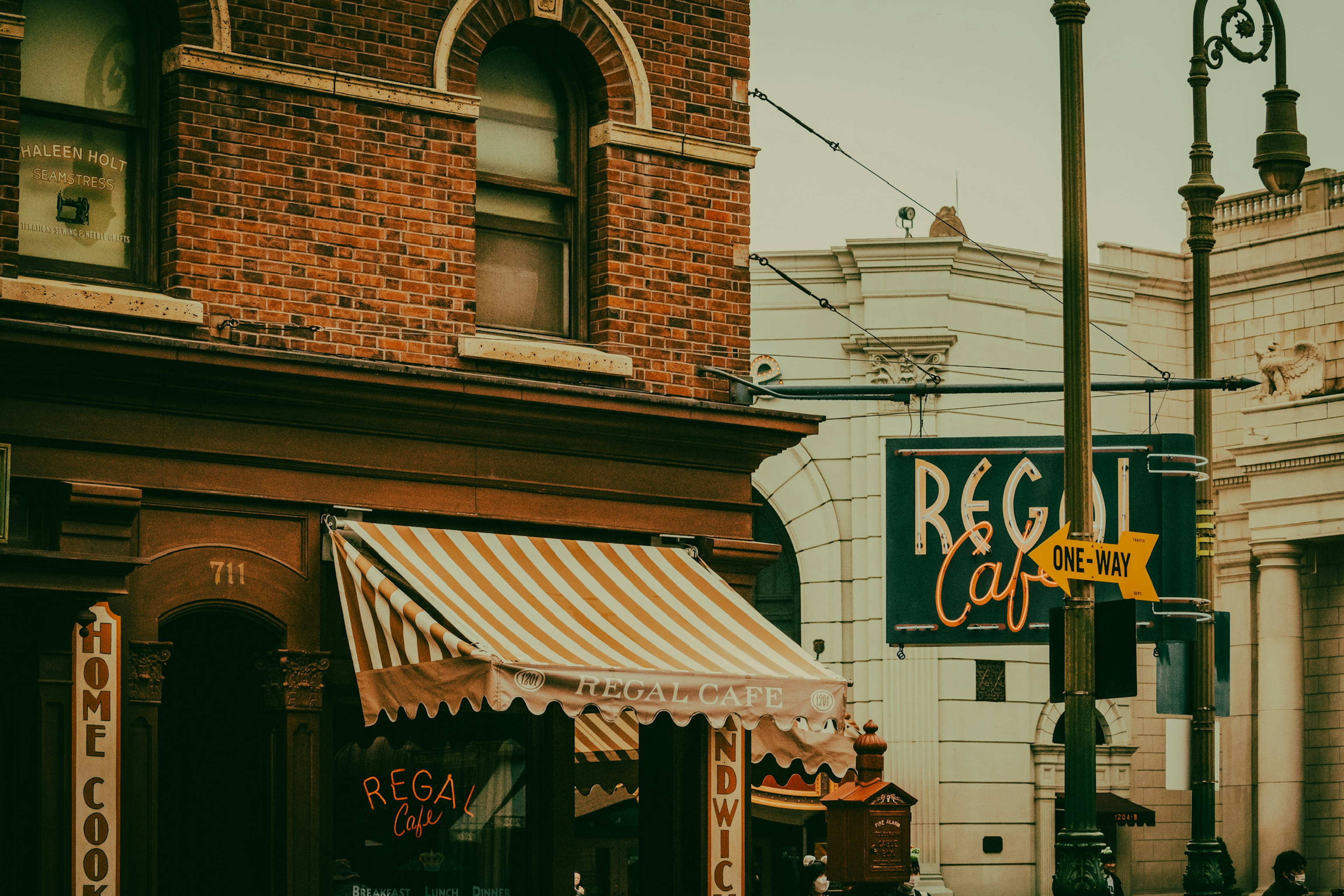 Extérieur d'un café vintage avec auvent rayé et mur en briques