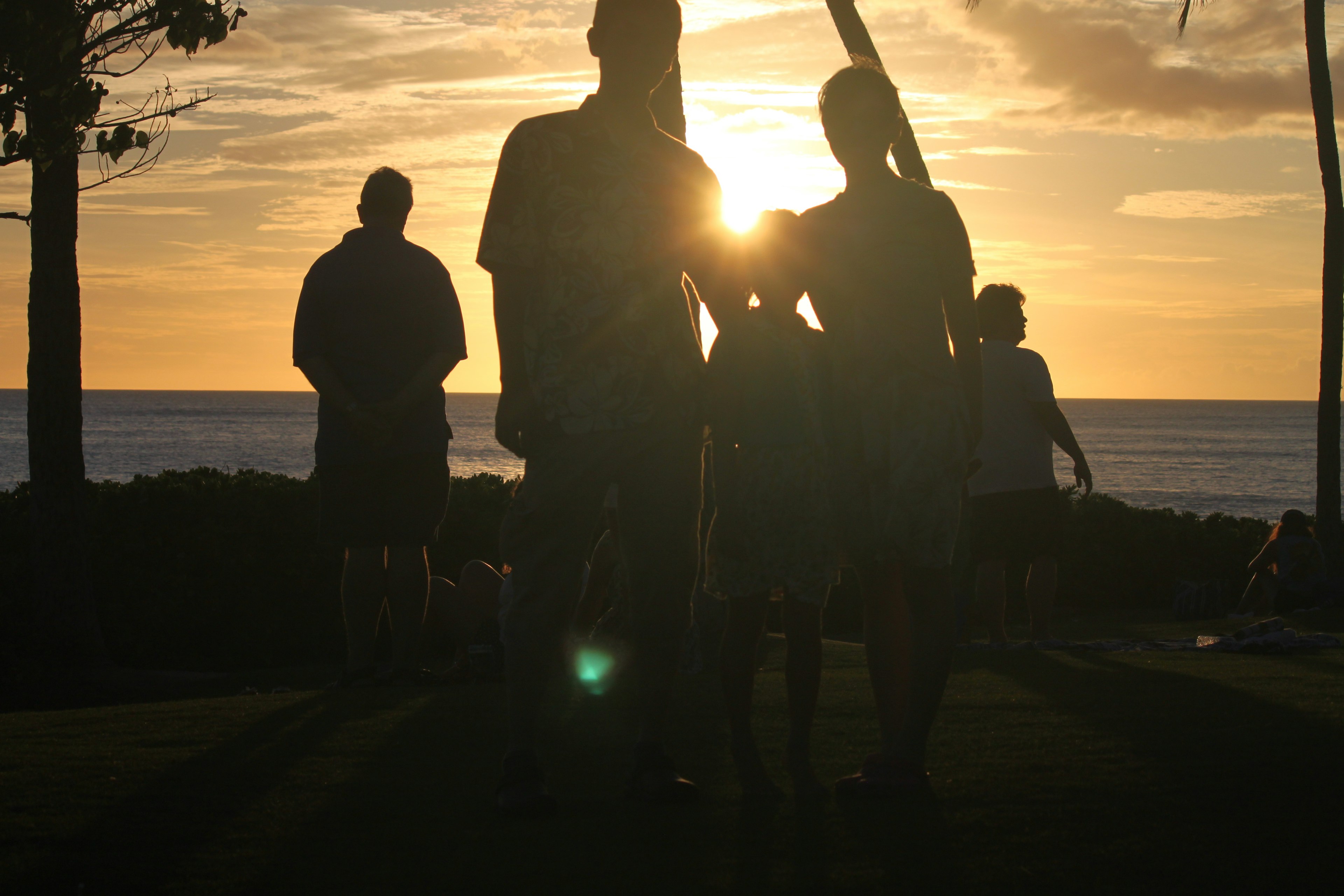 Silhouettes de personnes contre un coucher de soleil sur la plage