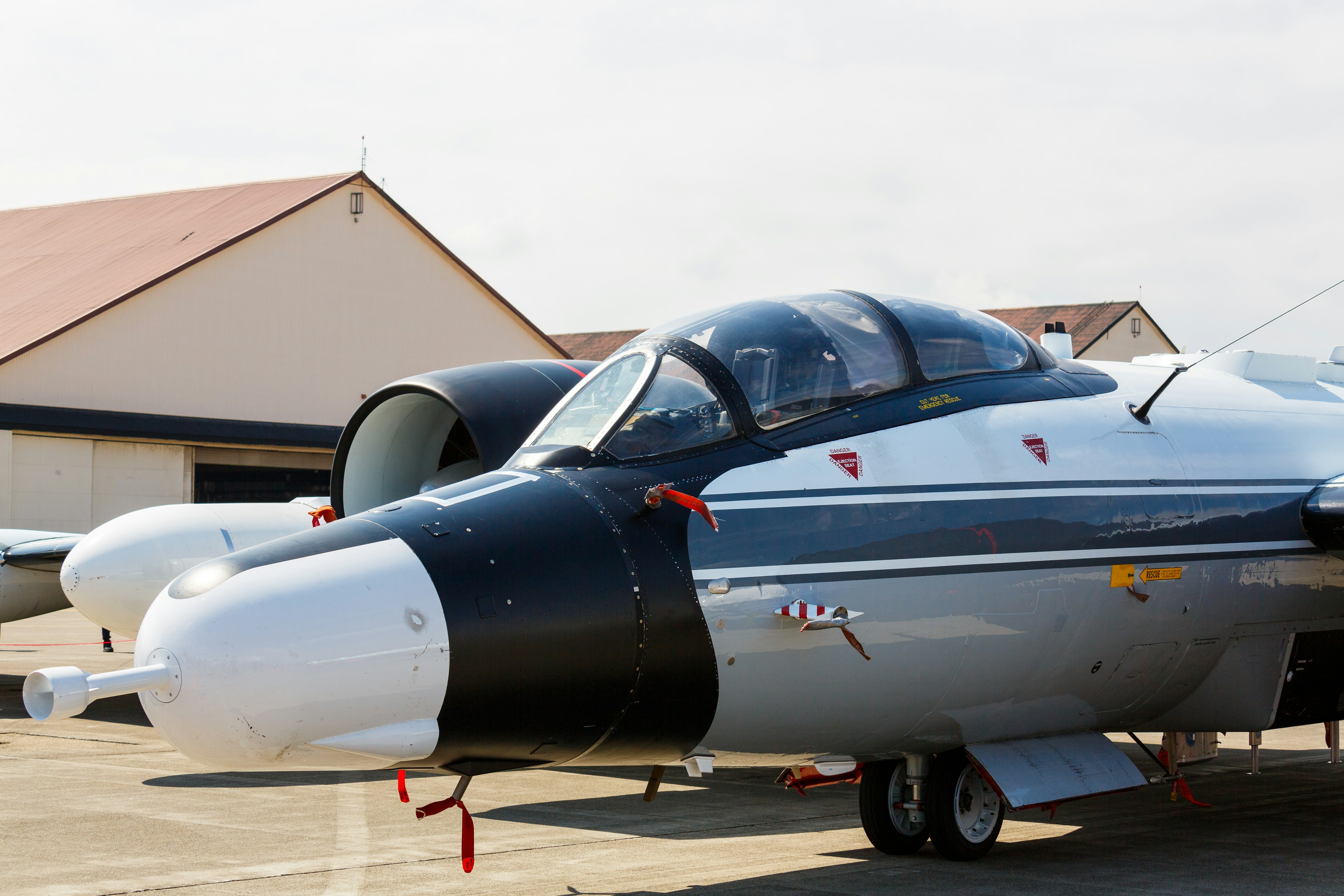 Nahaufnahme eines Flugzeugs auf der Startbahn mit schwarzer Nase und silbernem Rumpf