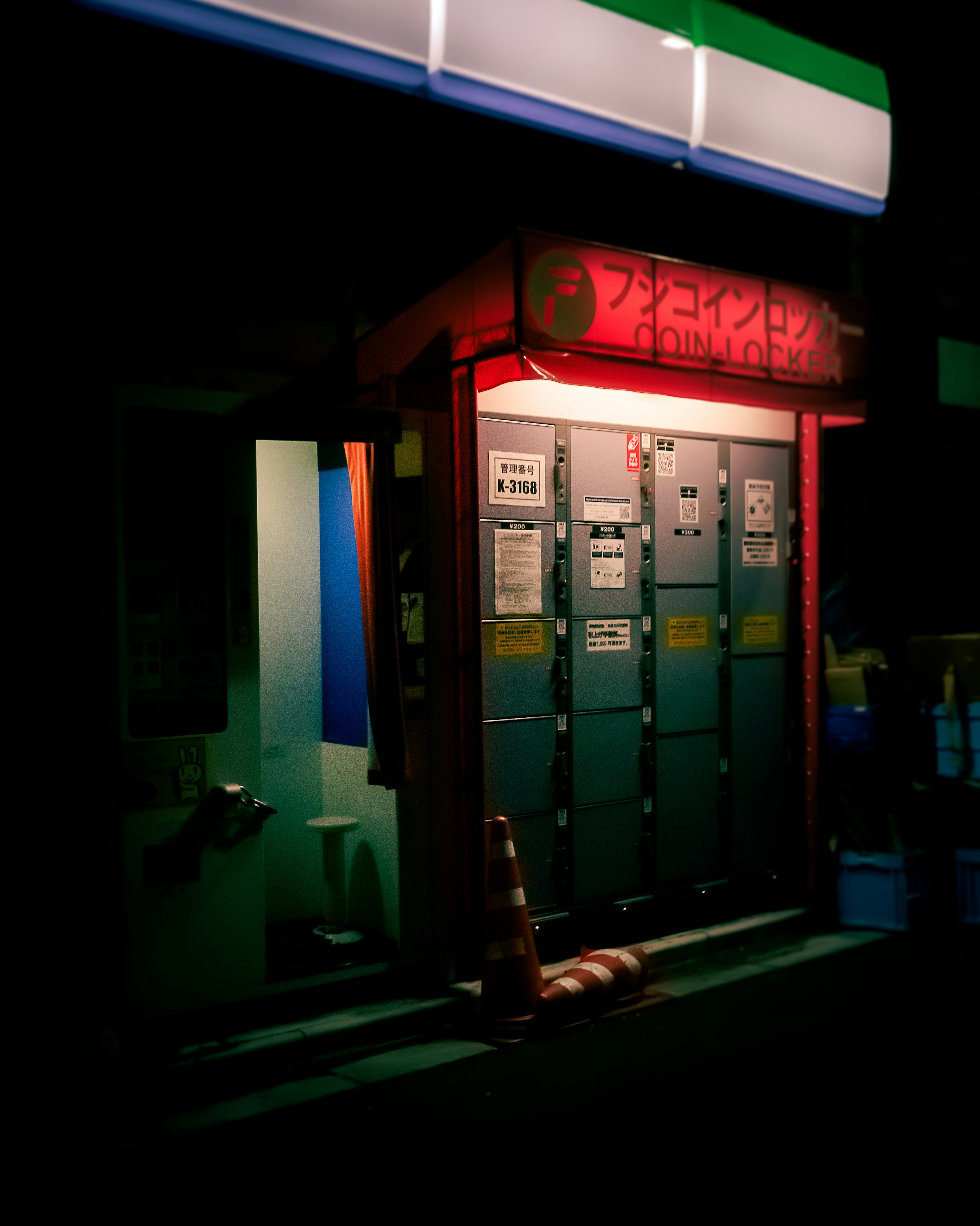 Nighttime scene of lockers with a red sign illuminated