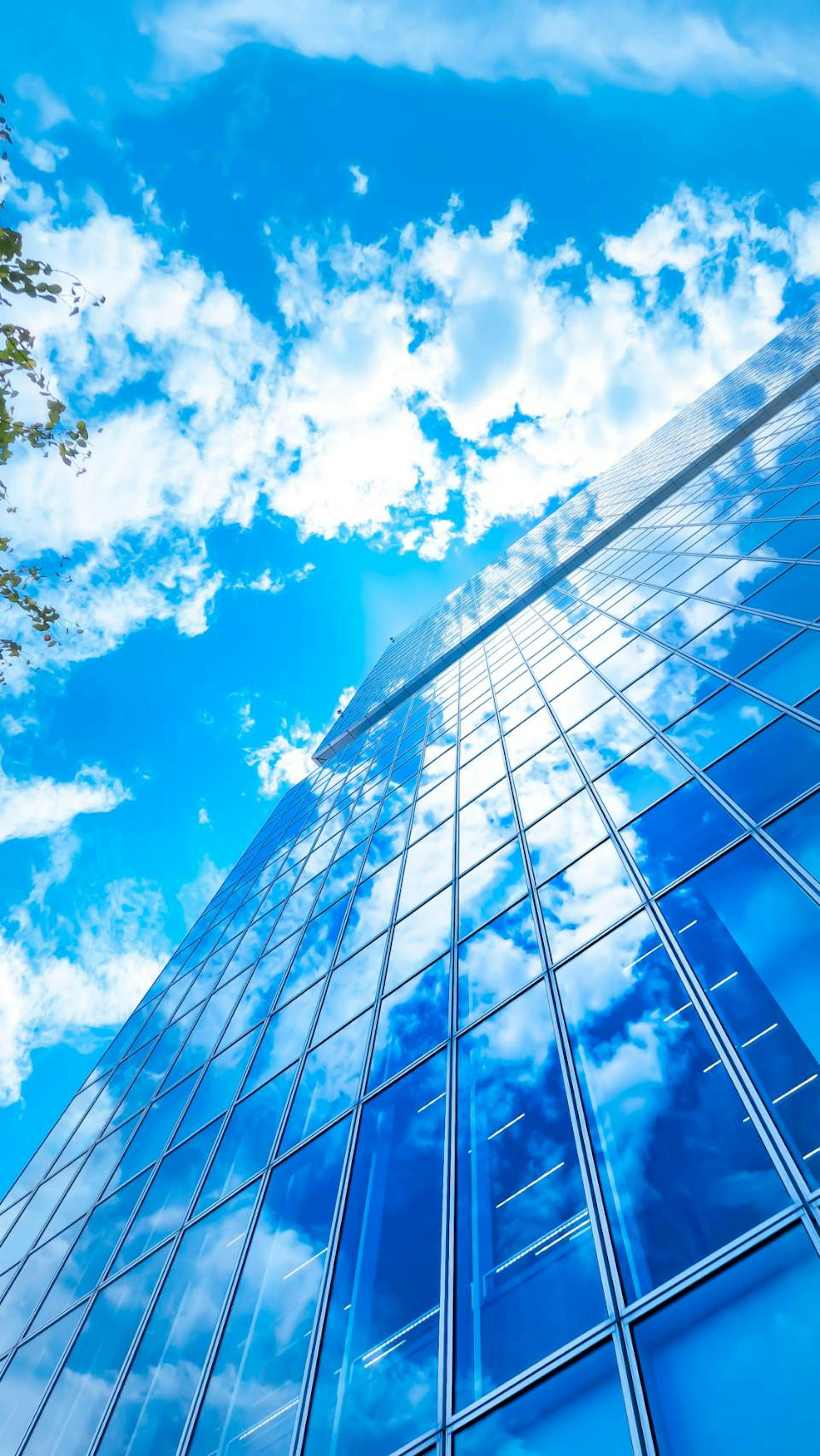 Gros plan d'un gratte-ciel reflétant le ciel bleu et les nuages