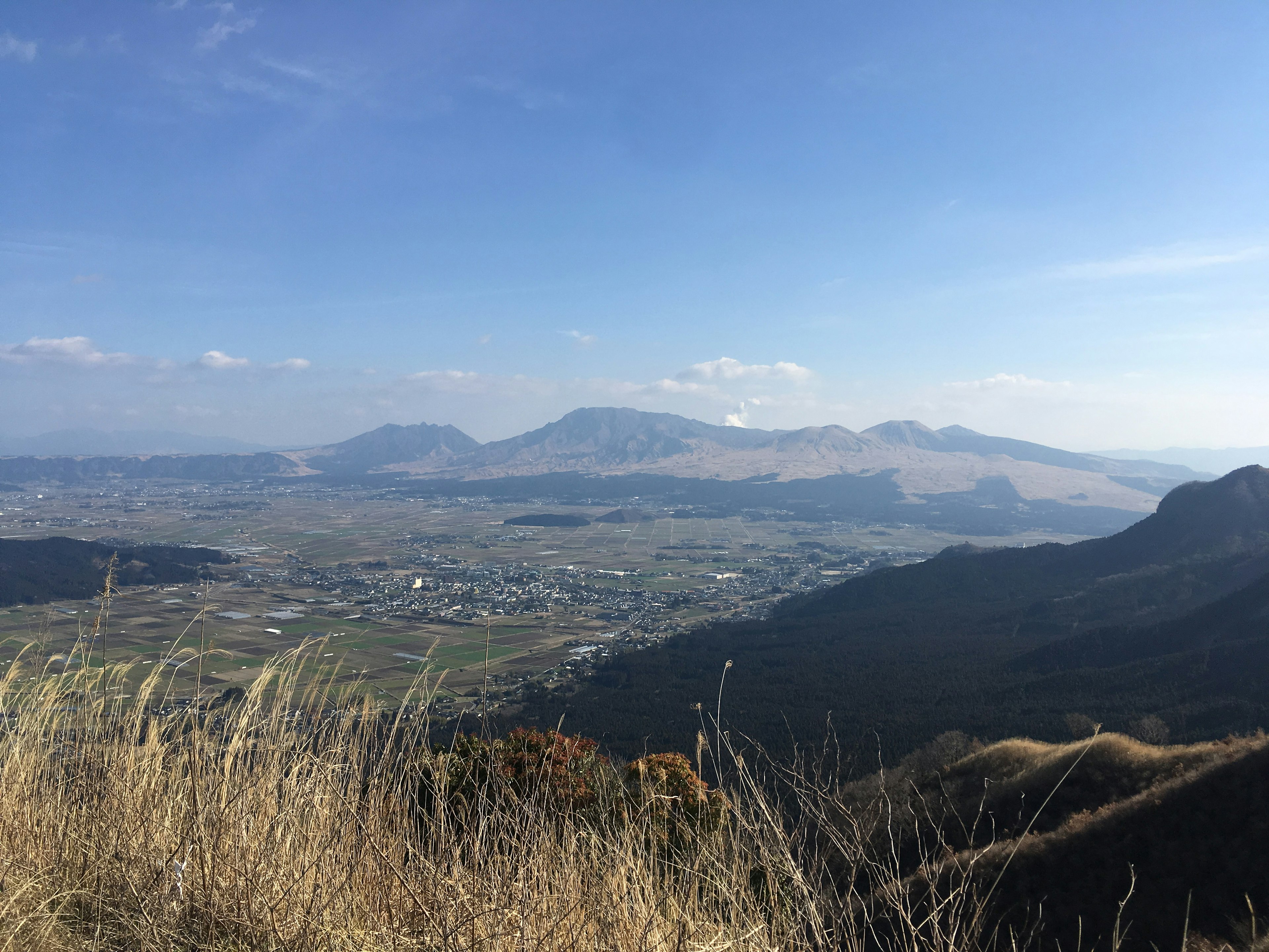 Vista panoramica di montagne e praterie sotto un cielo blu chiaro