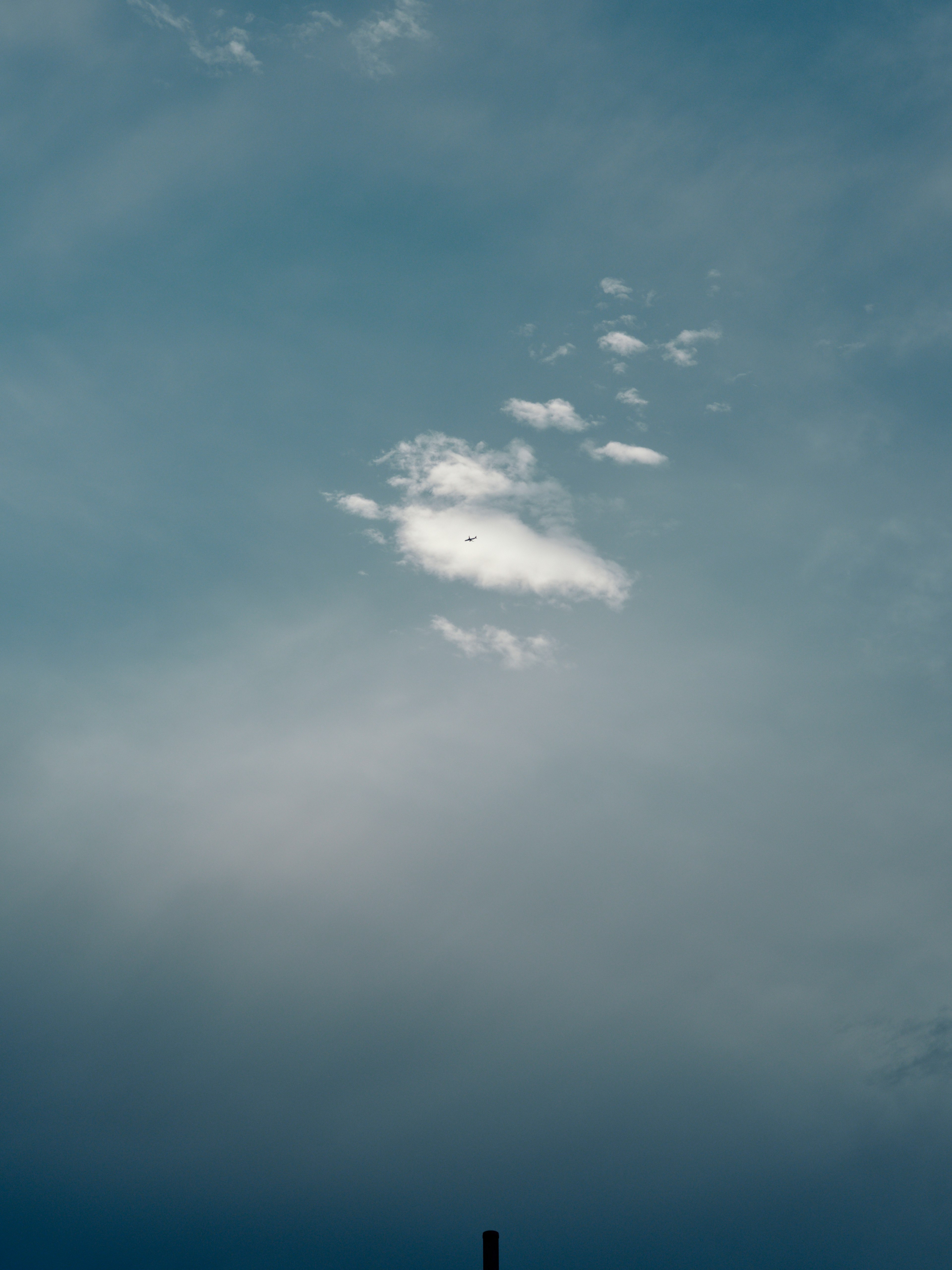 青い空に浮かぶ白い雲のシルエット