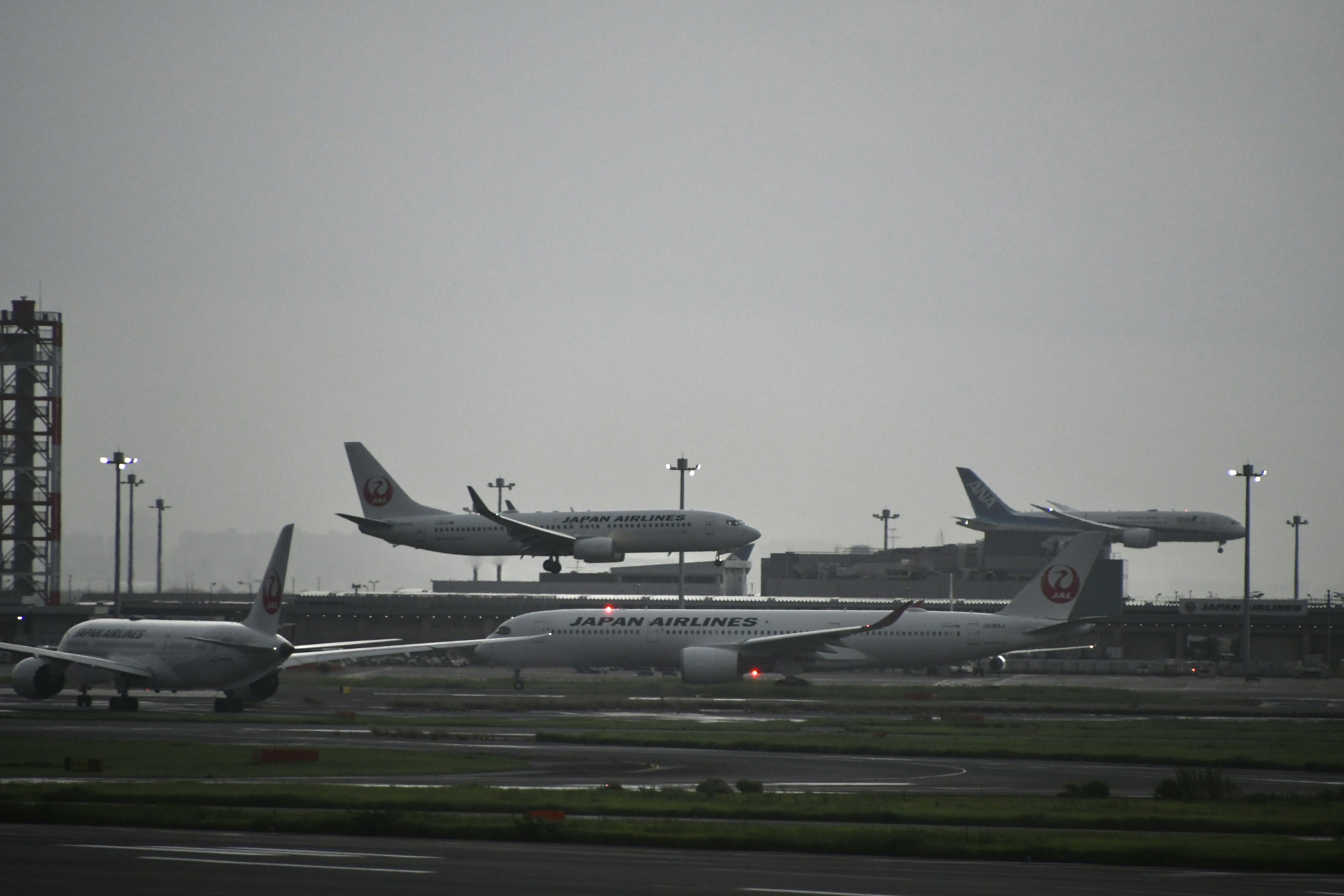 空港に着陸する航空機の群れと曇った空の風景