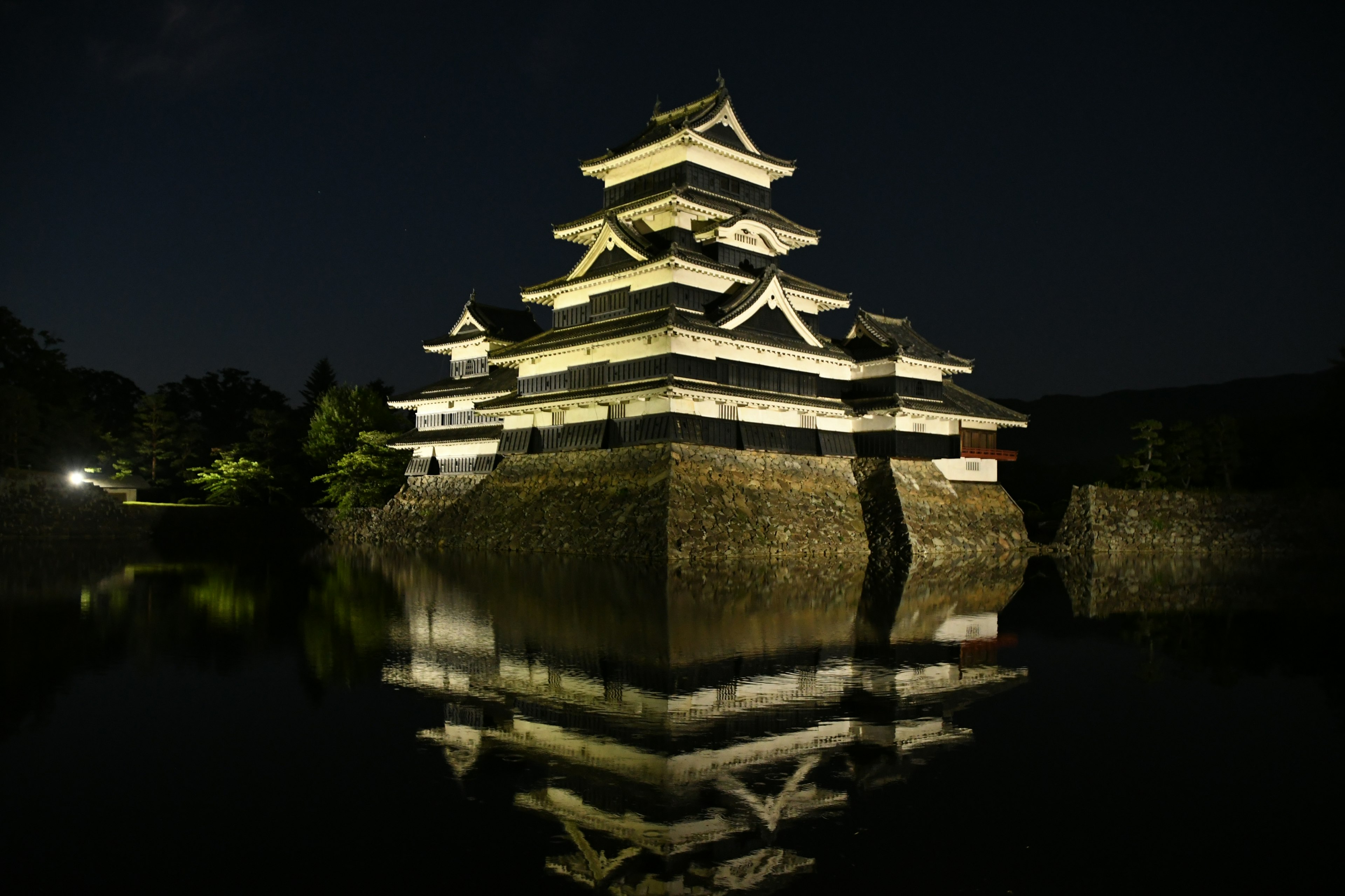 Kastil Matsumoto di malam hari dengan refleksi di air