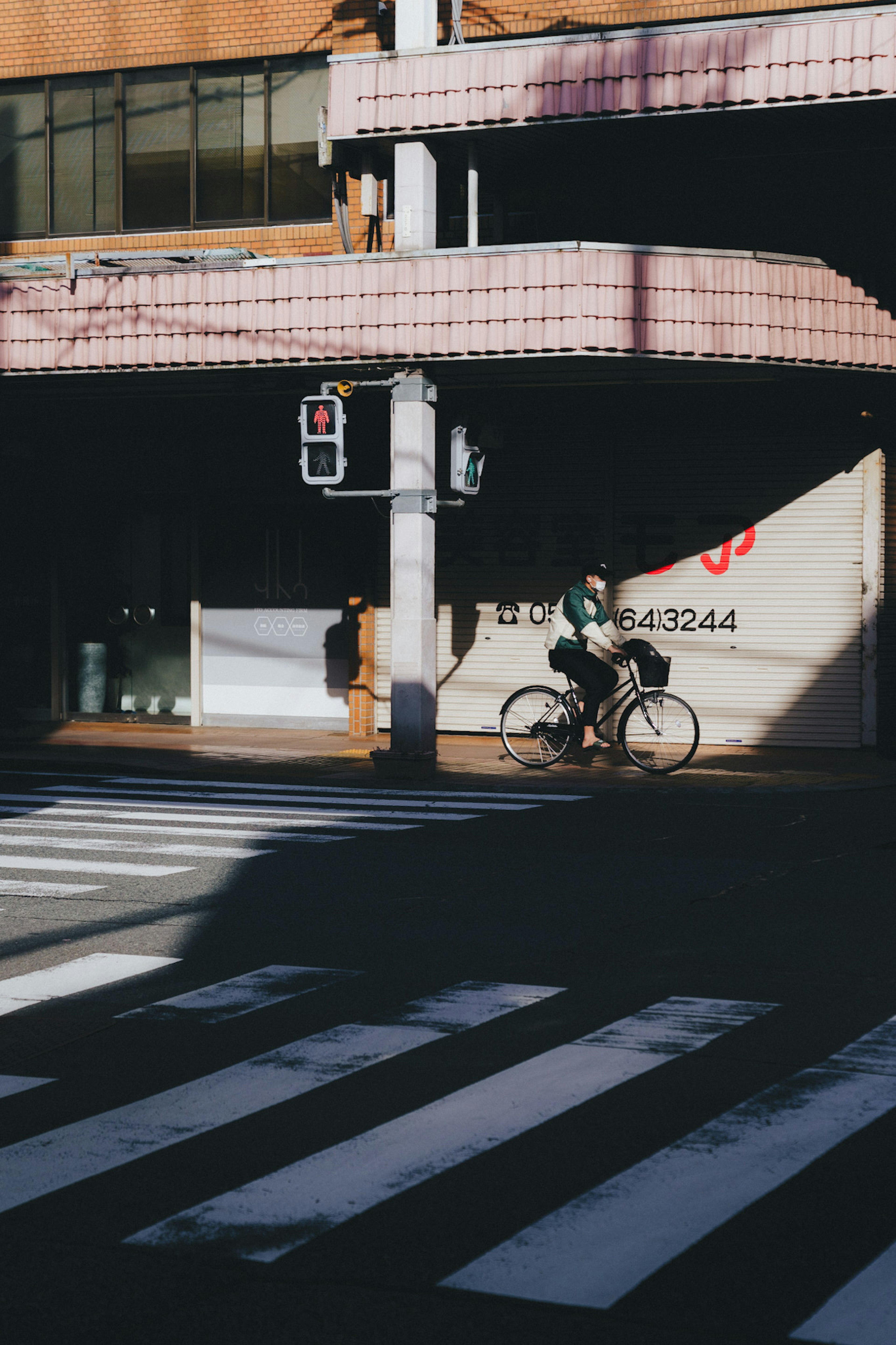 Eine Person, die auf einem Fahrrad neben einem Zebrastreifen mit städtischen Elementen fährt