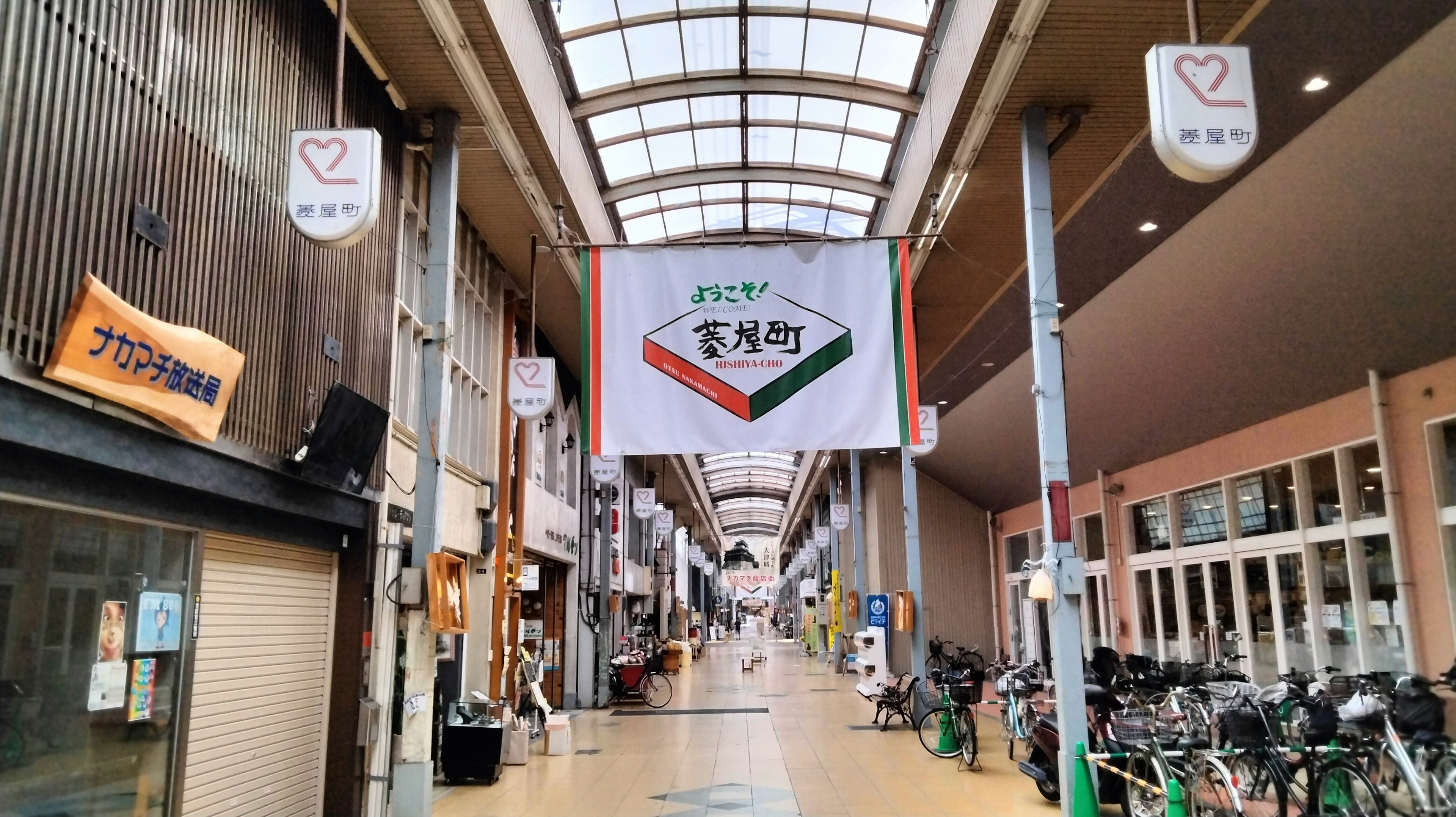 Arcada comercial interior con un gran cartel y bicicletas alineadas