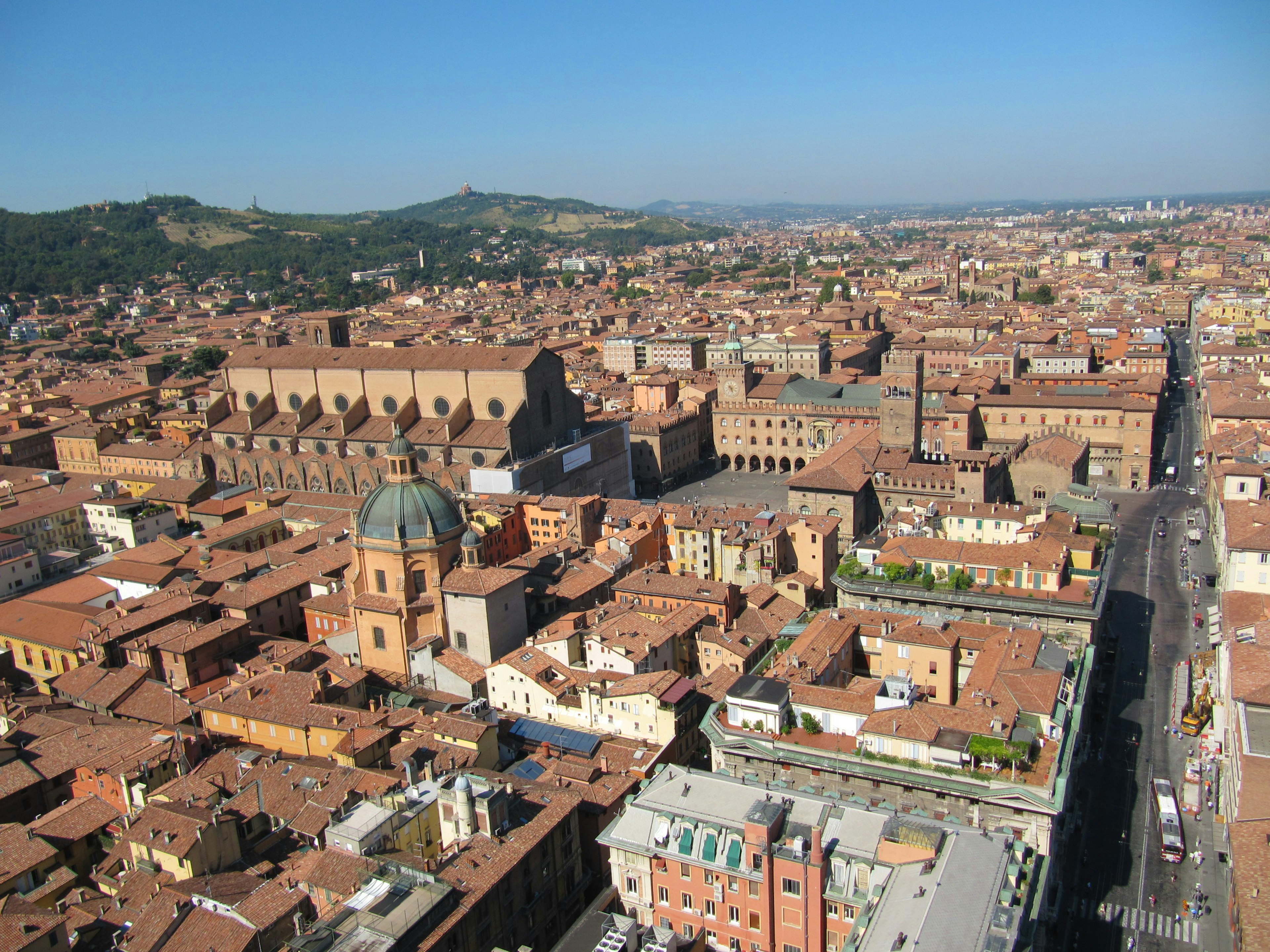 Aerial view of Bologna showcasing red rooftops and blue sky