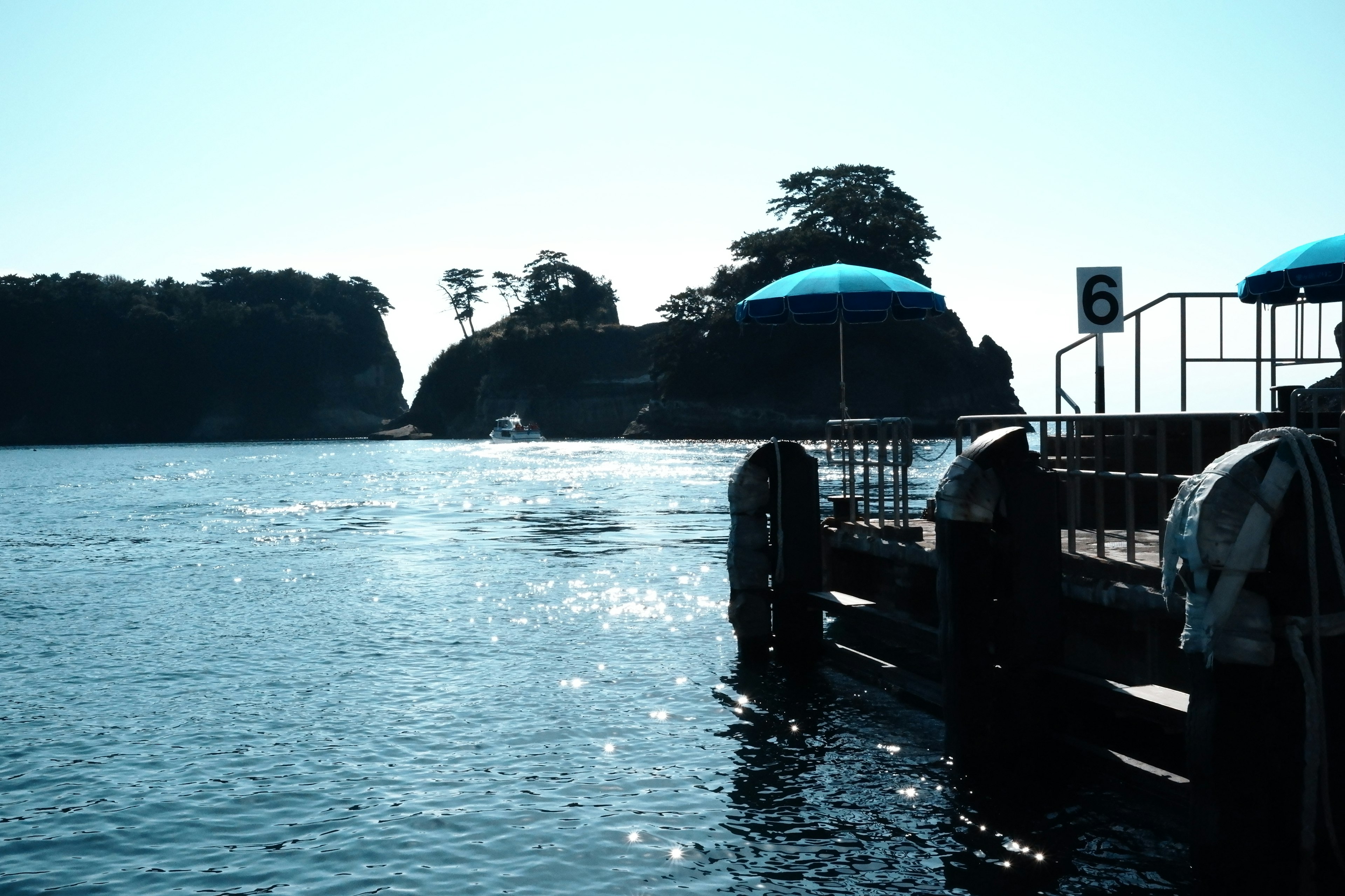 Pemandangan indah sebuah pulau kecil dan dermaga di bawah langit biru cerah