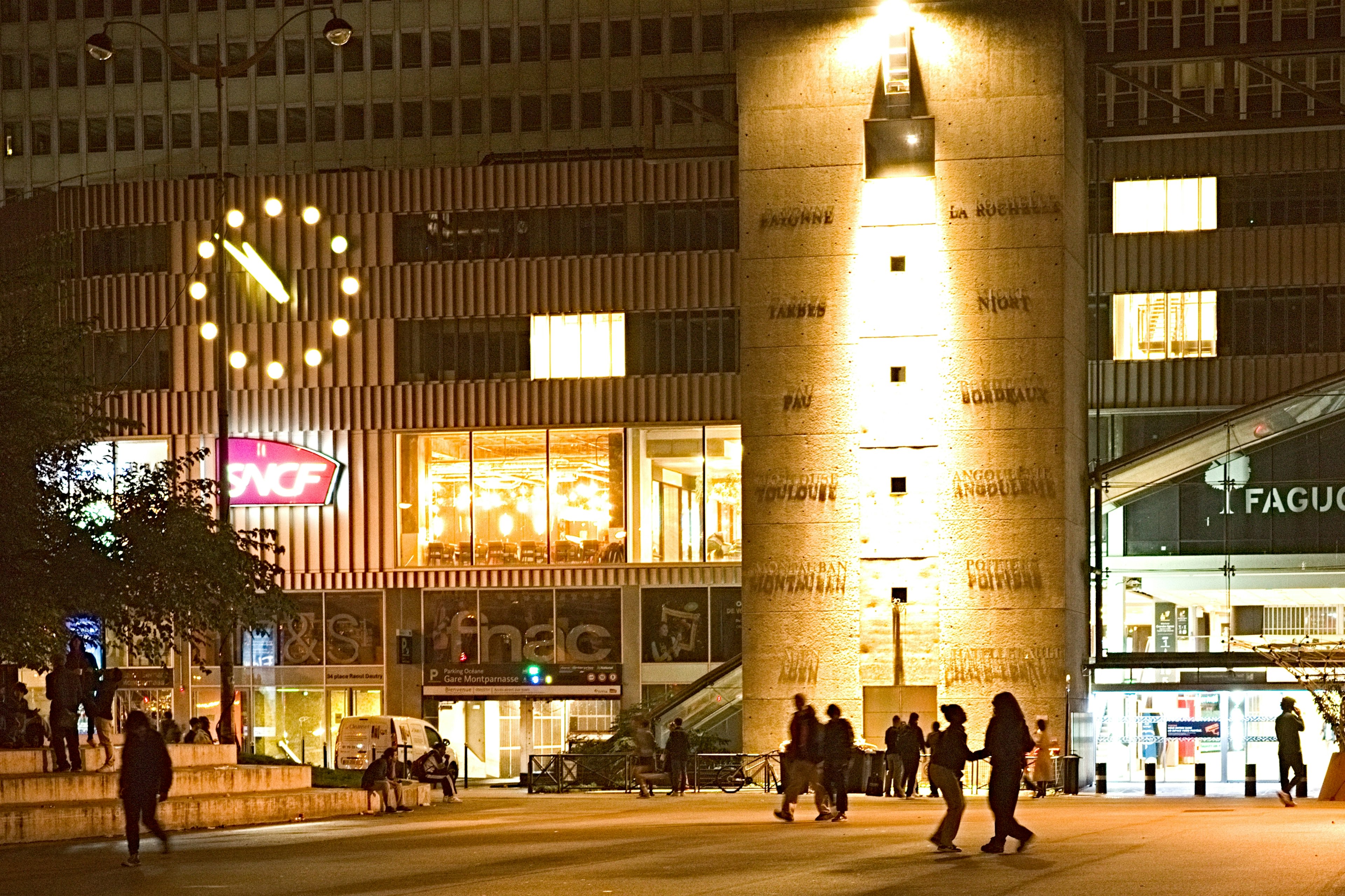 Escena urbana nocturna con edificios iluminados y un reloj