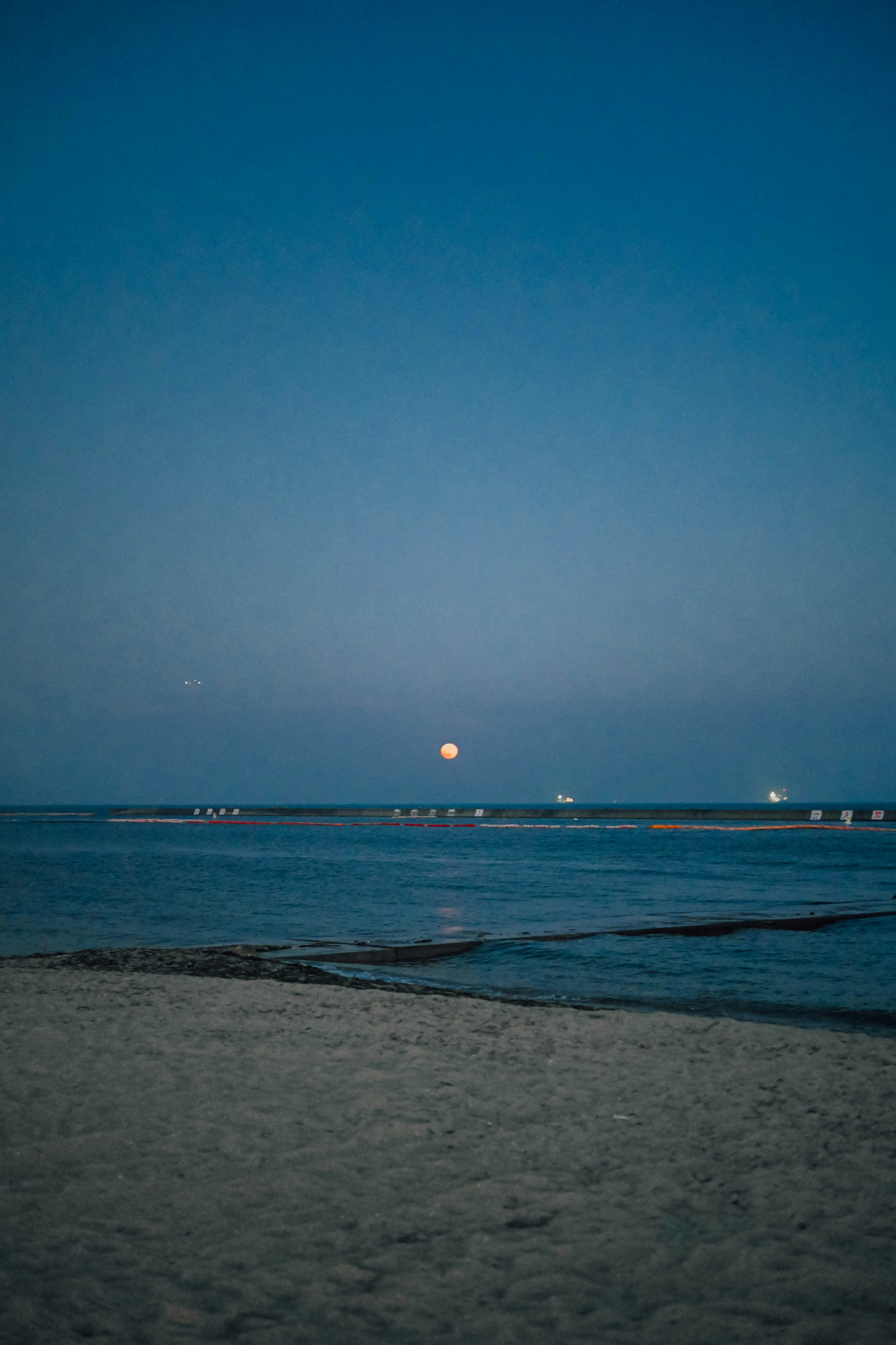 夜晚海滩场景，明月和宁静的水面