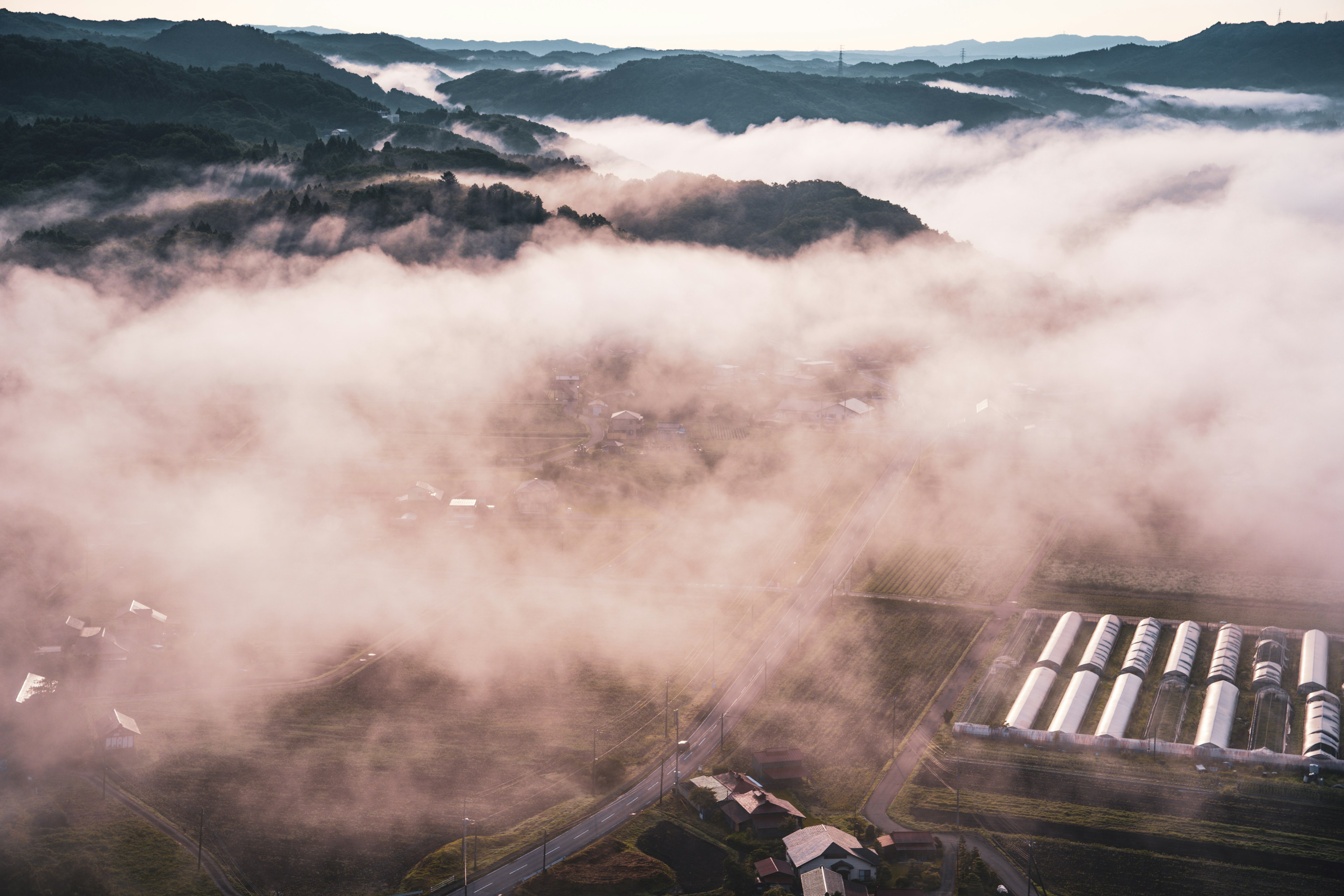 Aerial view of mountains and farmland shrouded in fog