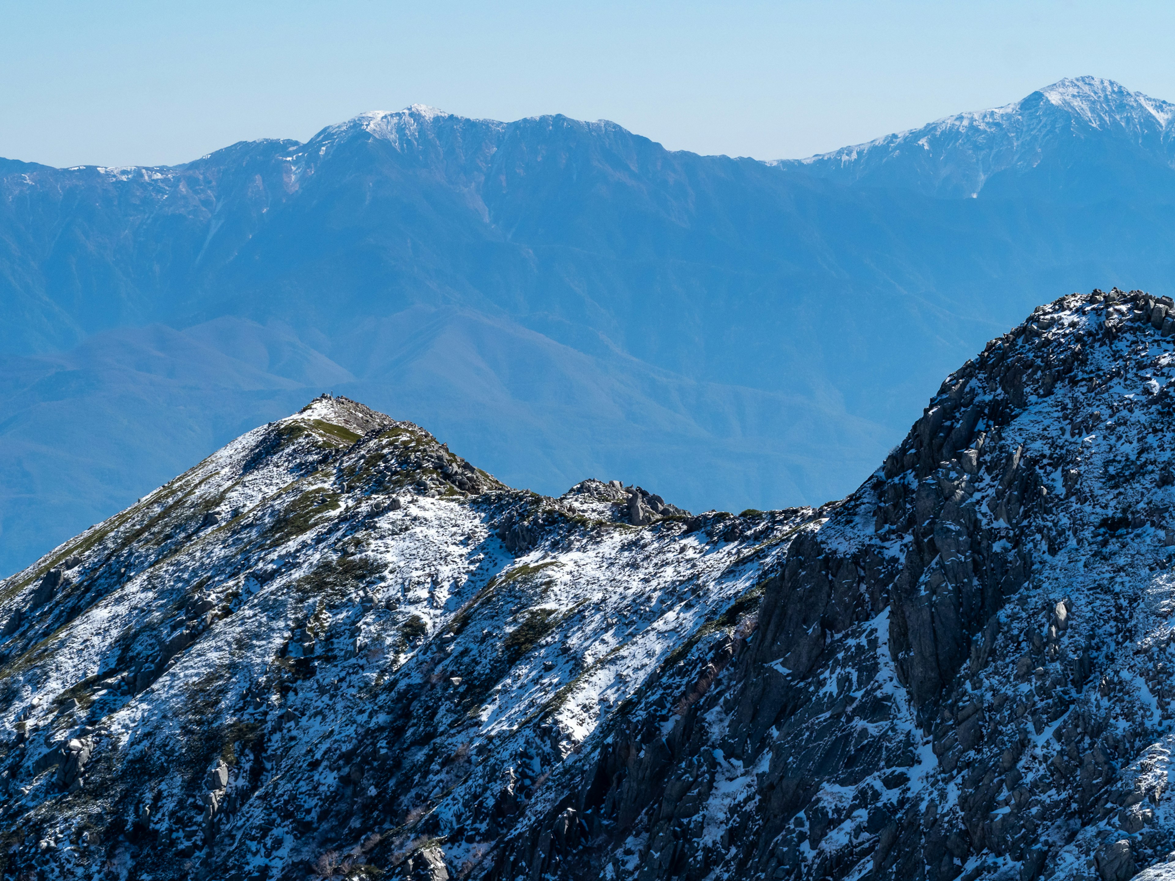 Snow-covered mountain landscape with clear blue sky