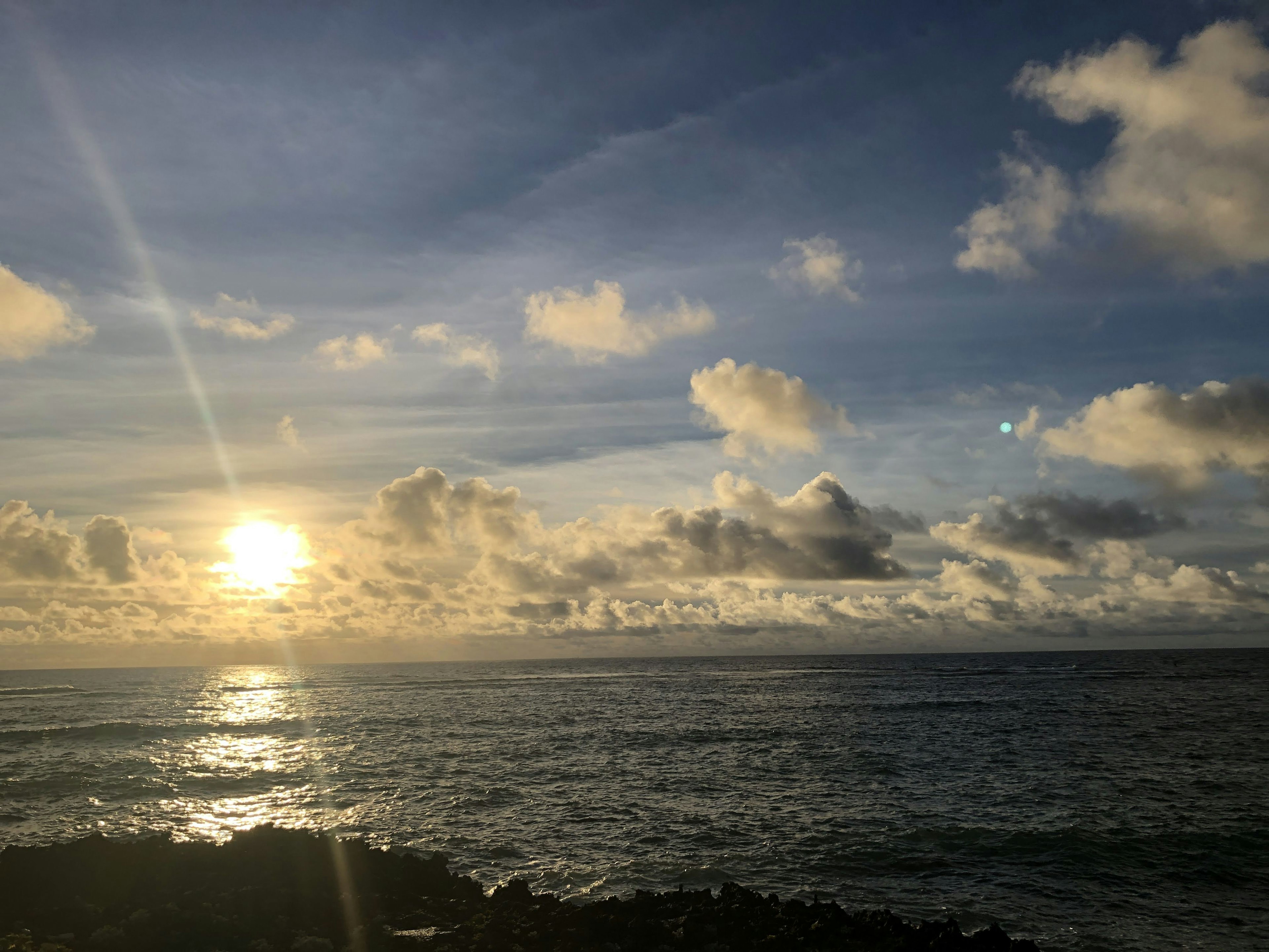 Tramonto sull'oceano con nuvole nel cielo