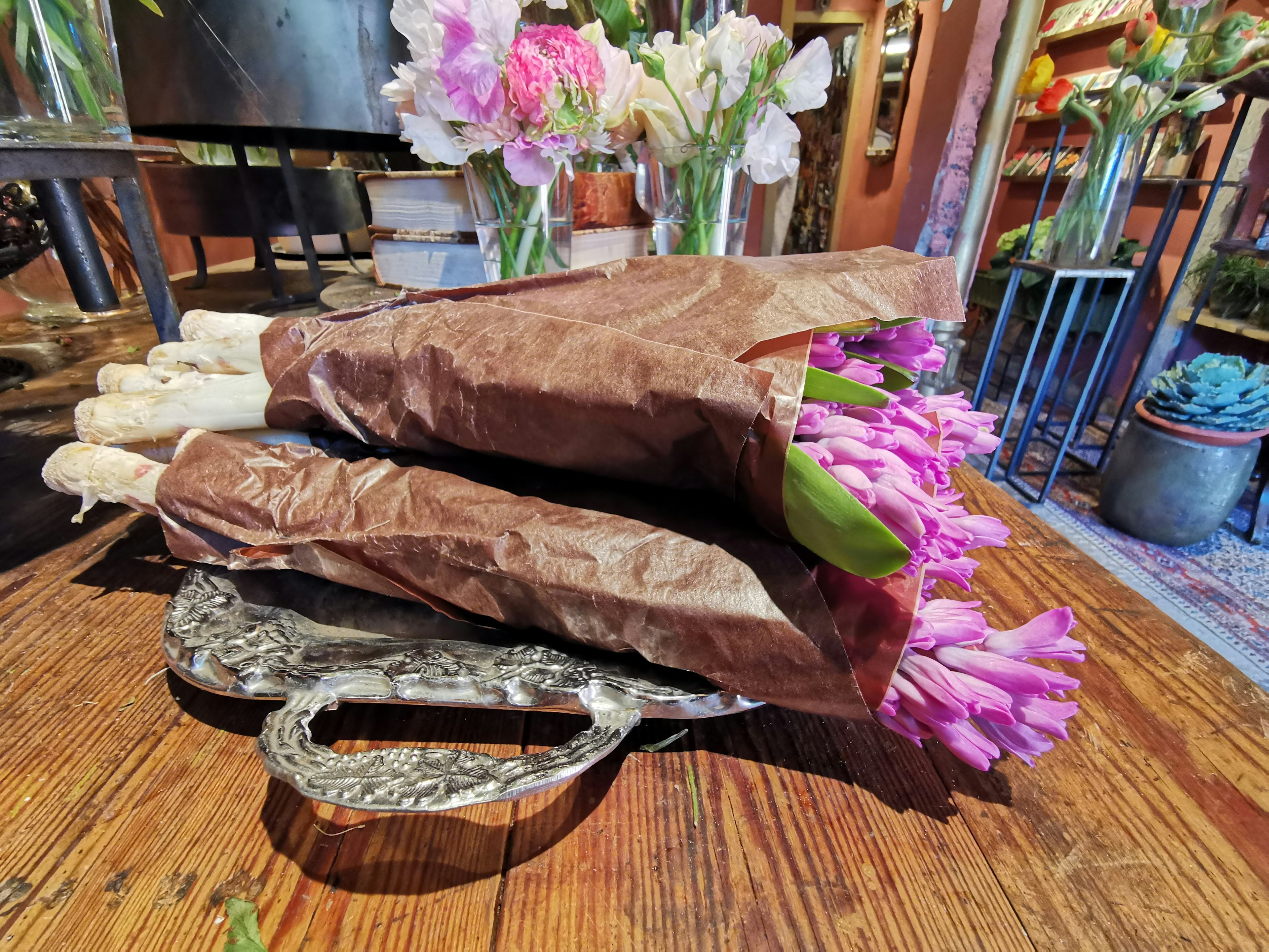 Bouquets de tulipes violettes enveloppés dans du papier brun placés sur une table en bois