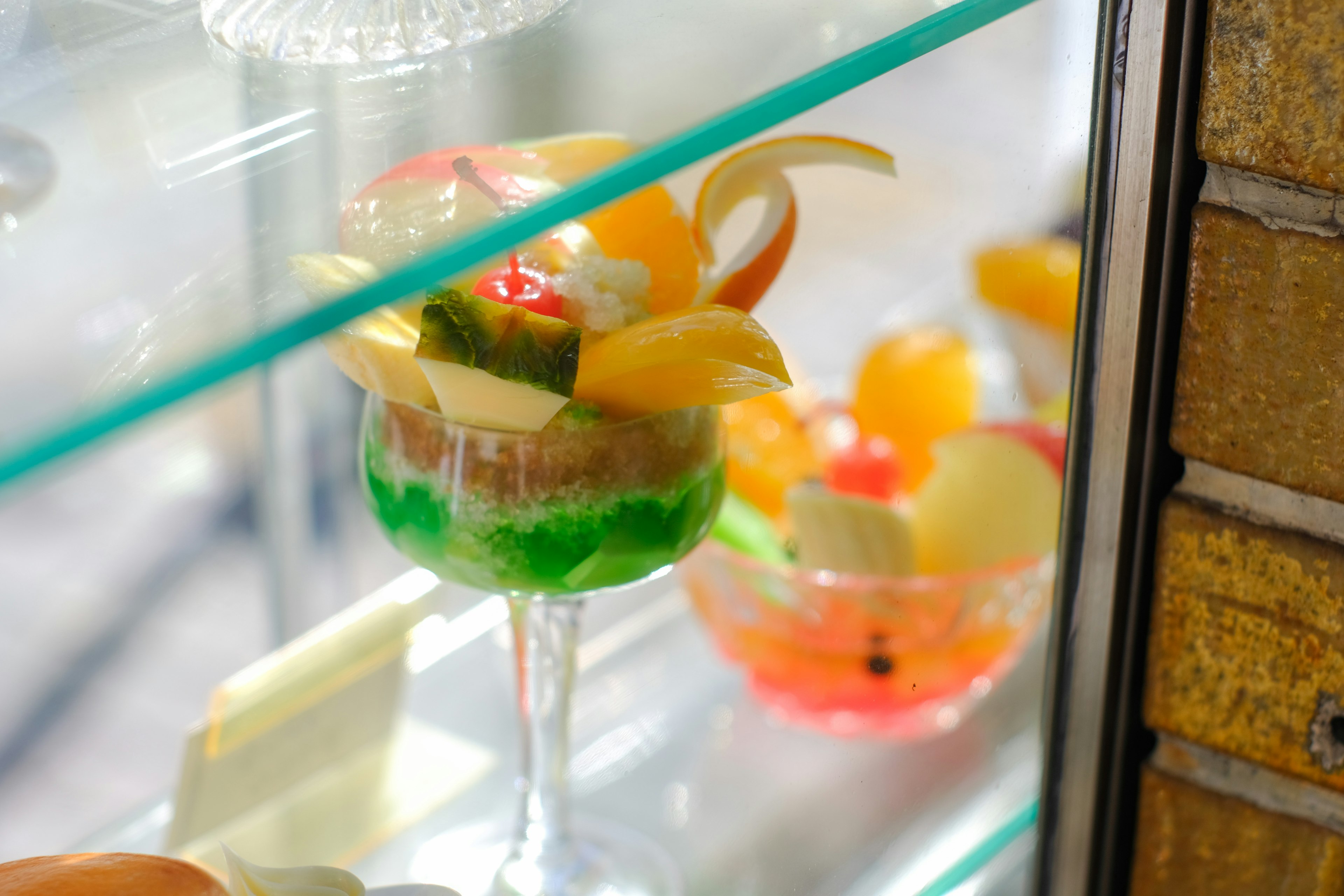 Colorful dessert cup with fruits displayed in a glass case