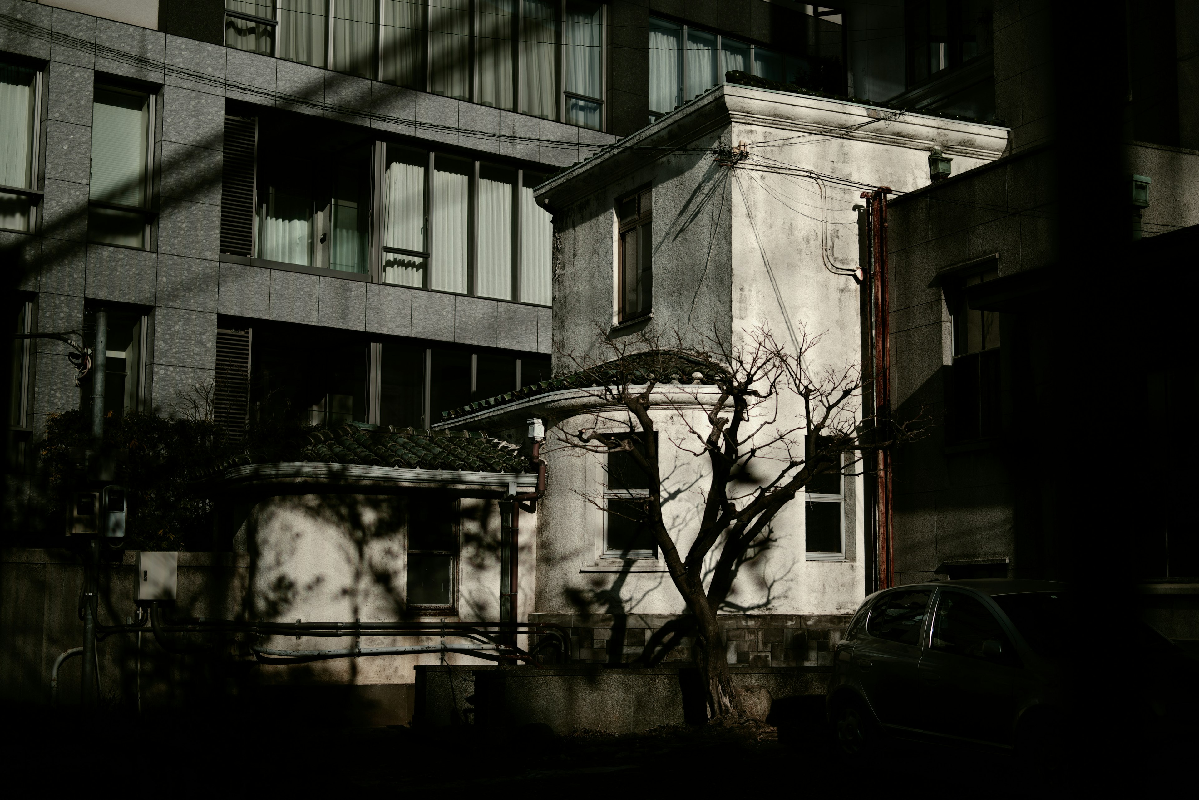 Un edificio blanco antiguo contrastado con un entorno oscuro y sombras