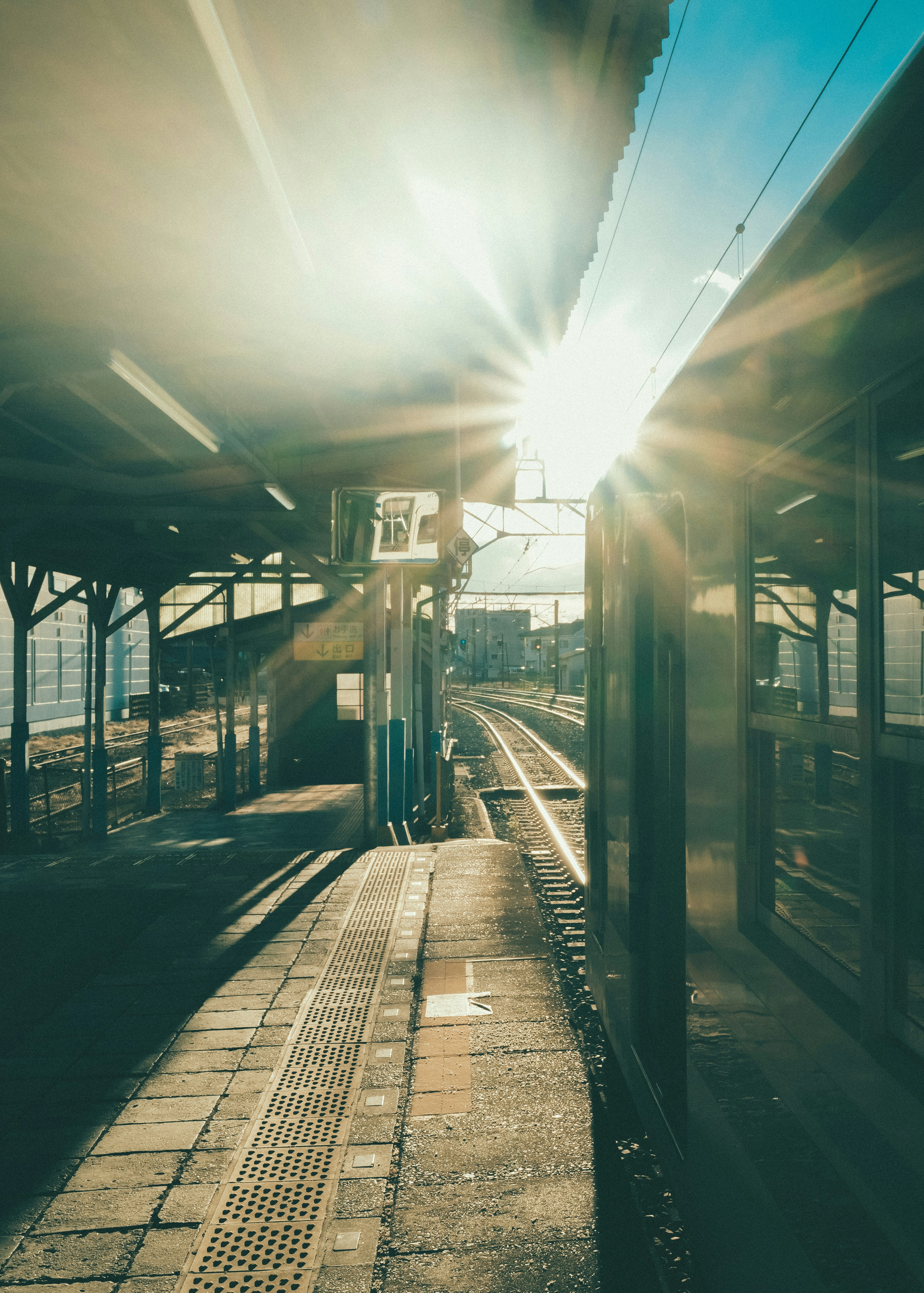 Kereta di platform dengan sinar matahari di latar belakang