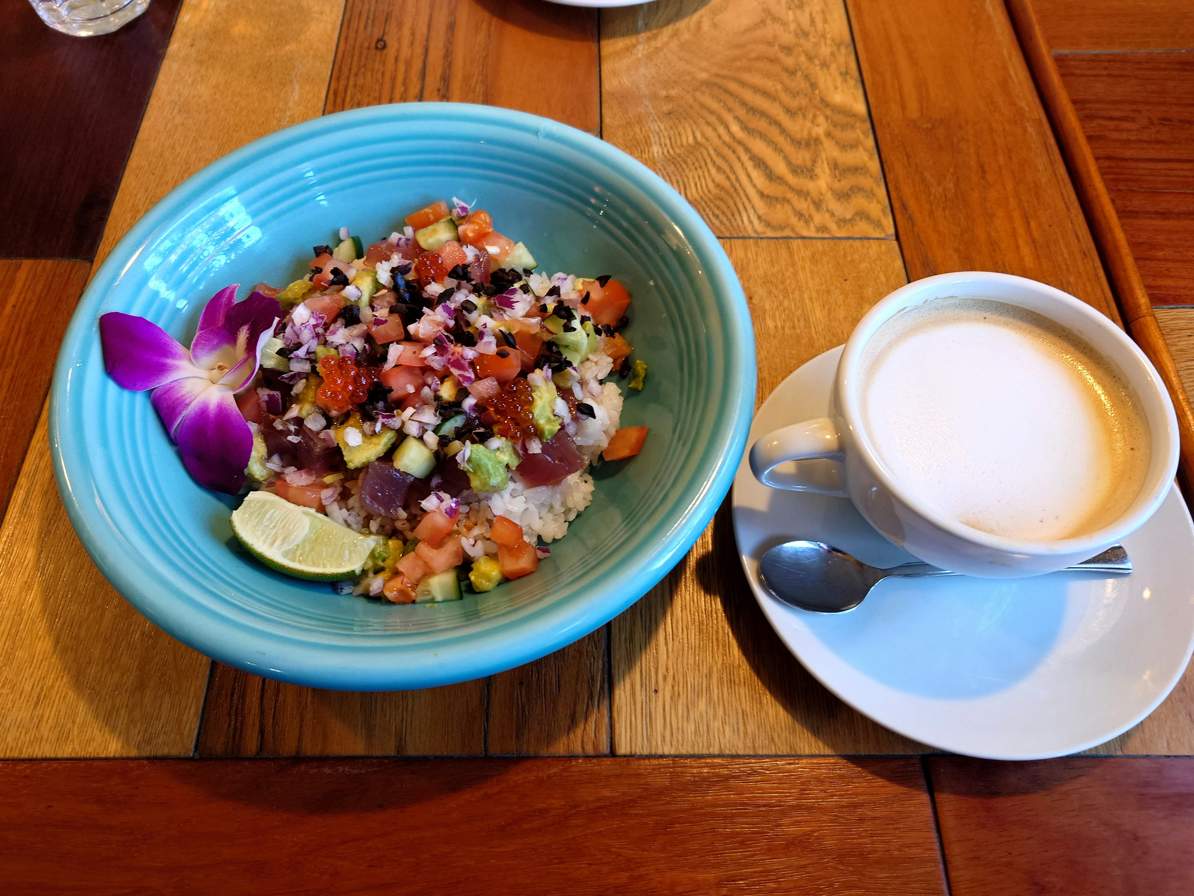 Ein bunter Salat in einer blauen Schüssel mit einer Tasse Kaffee daneben