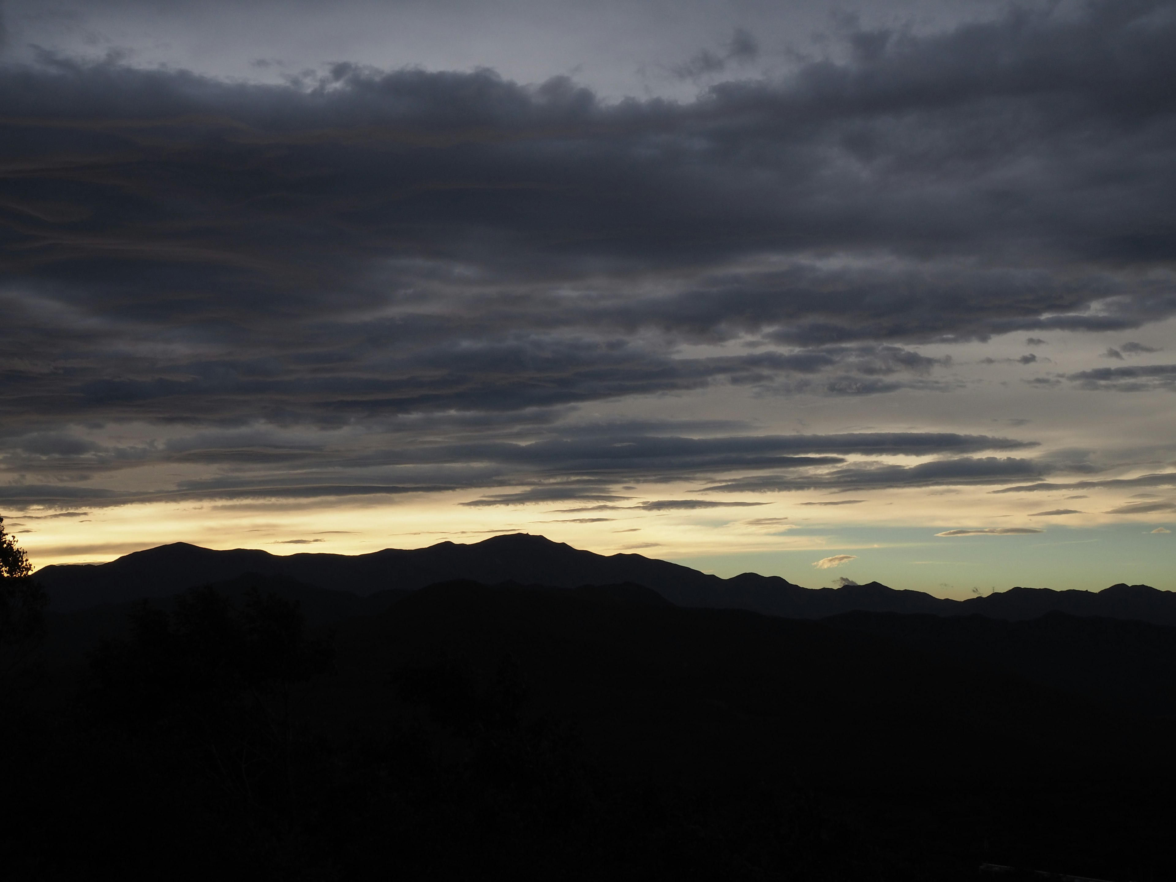 暗い雲に覆われた夕暮れの山々