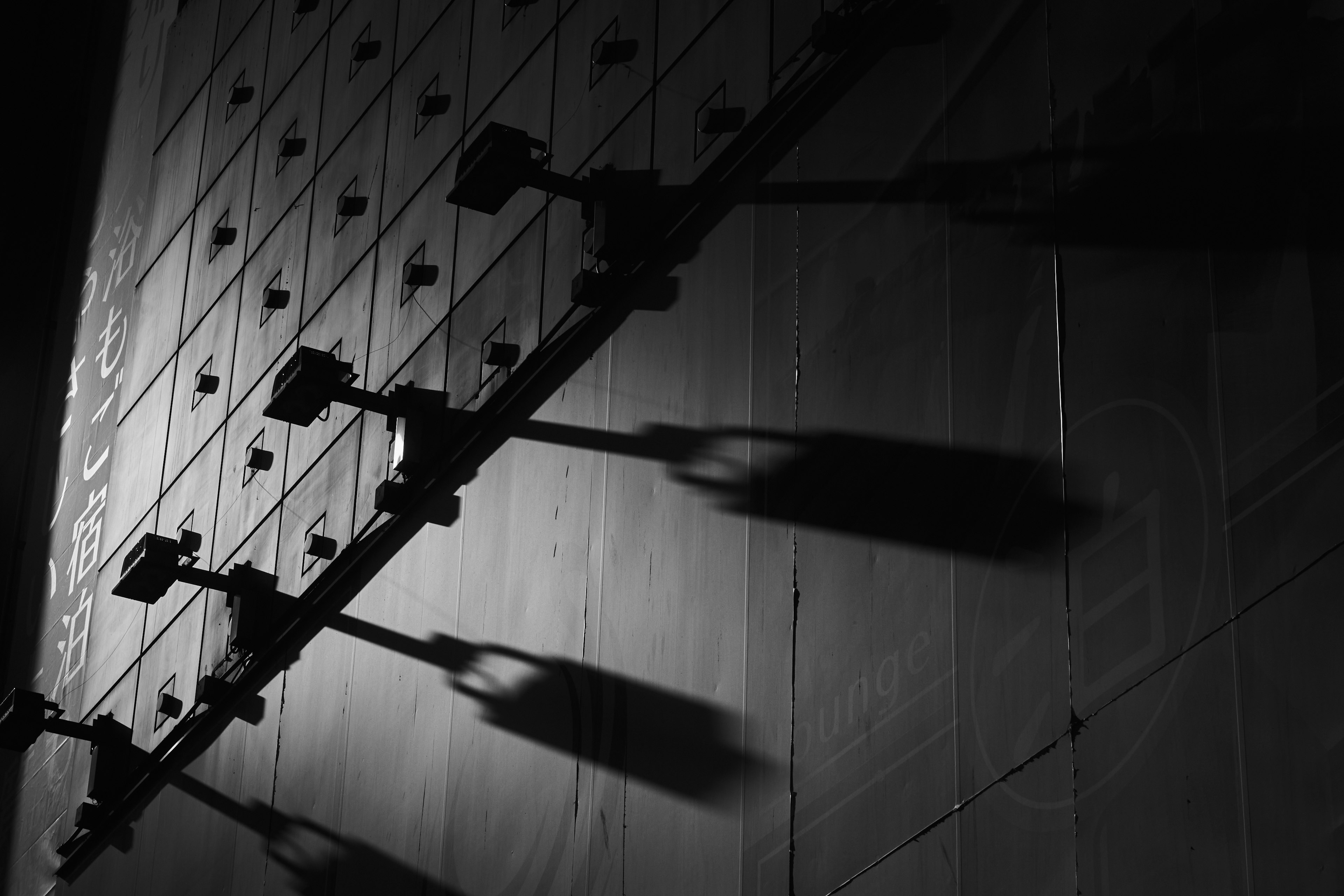 Sombras de farolas proyectadas en una pared oscura