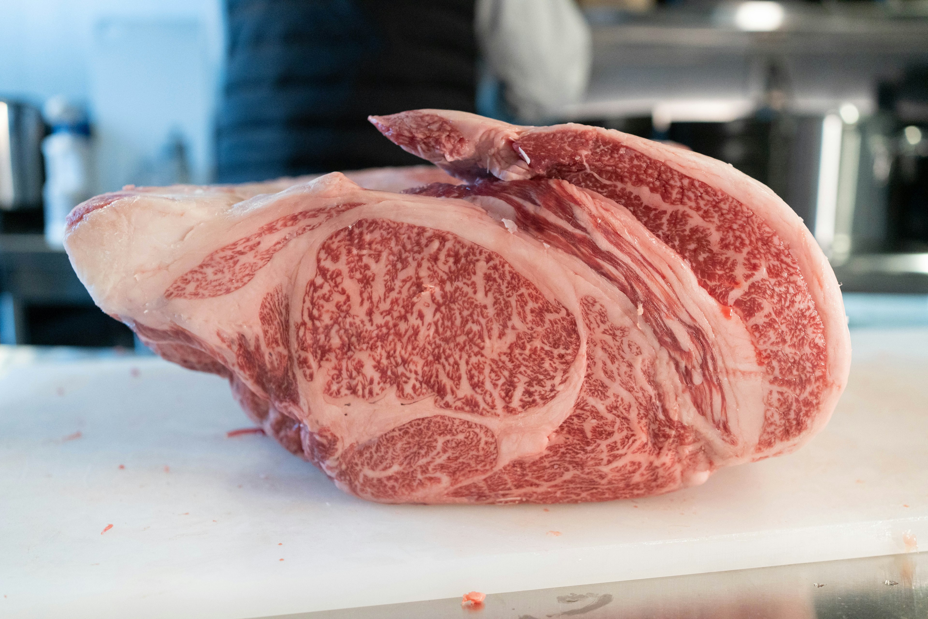 A beautiful marbled cut of Wagyu beef resting on a white cutting board