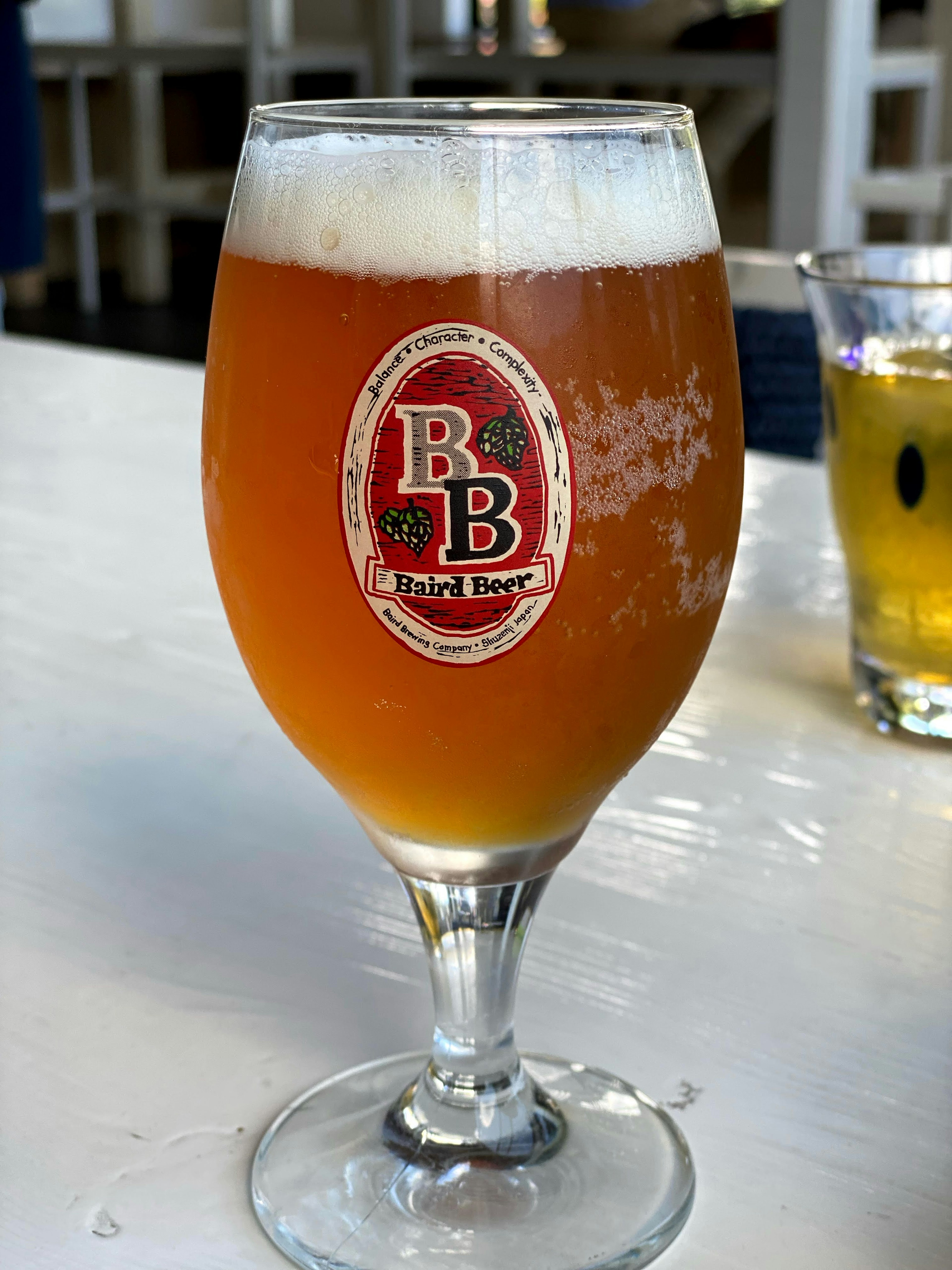 Ein Glas Bier mit einem roten Etikett auf einem Tisch