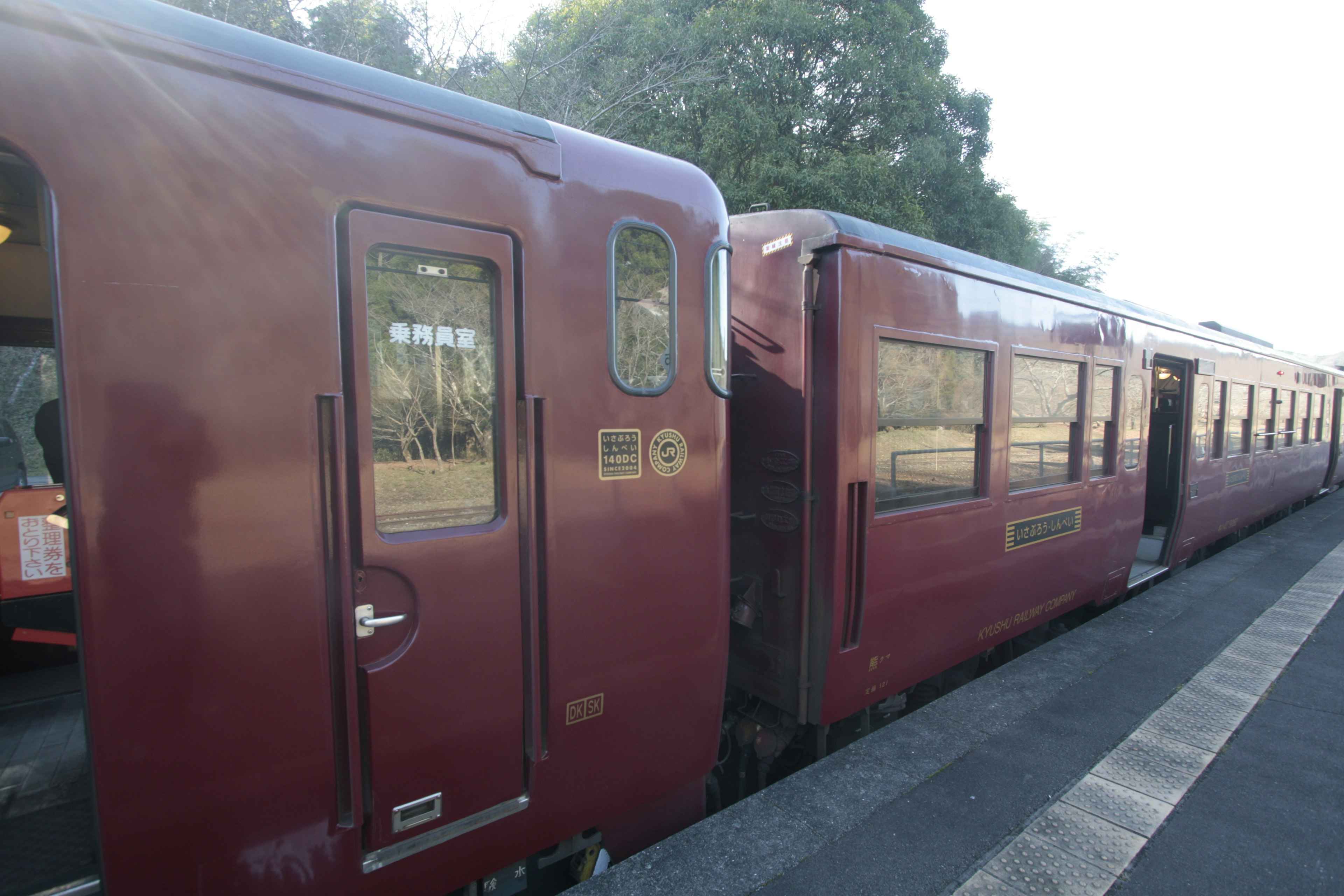 Red train cars parked at a station