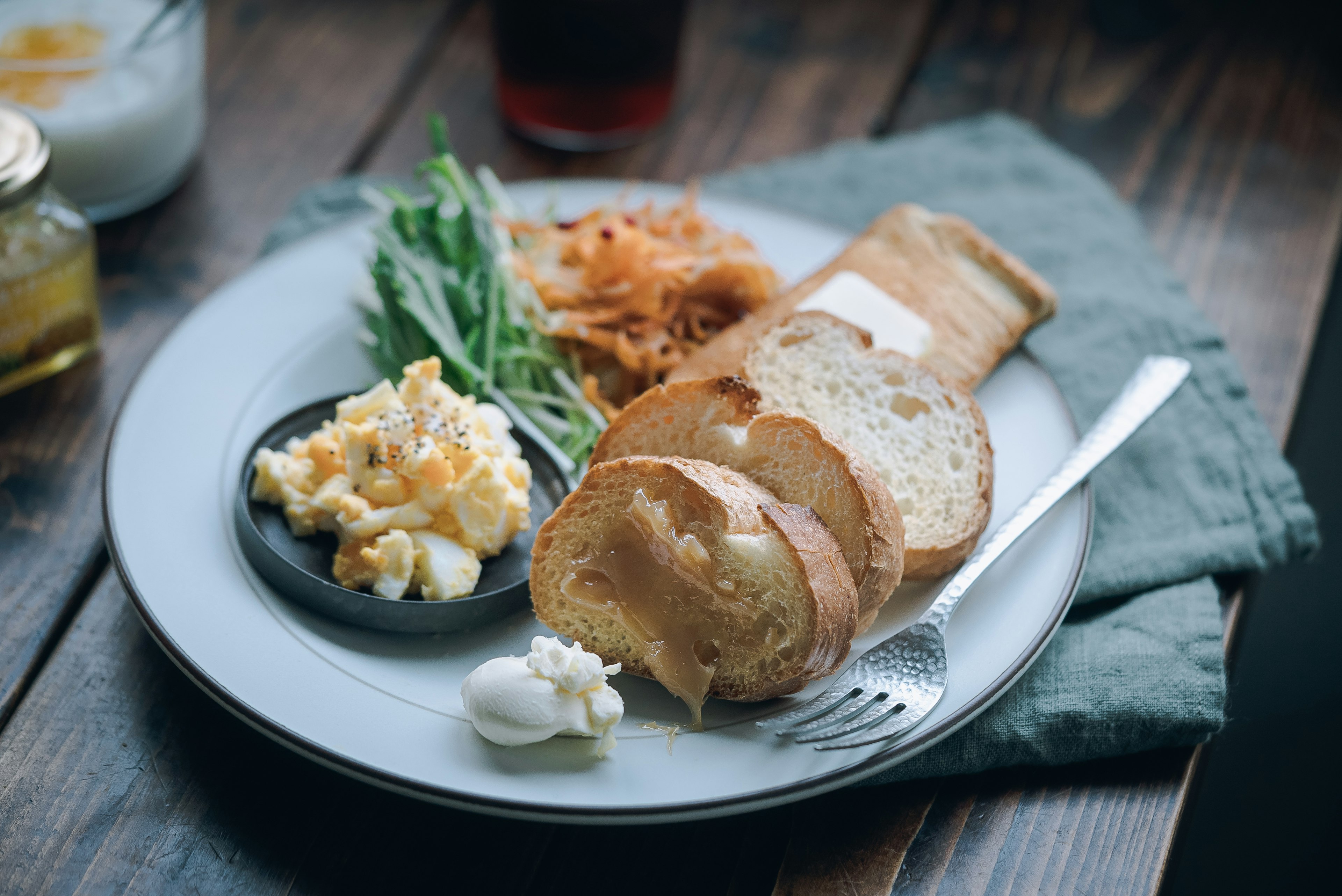 Assiette de petit-déjeuner avec des œufs brouillés, du pain, des légumes et de la crème aigre