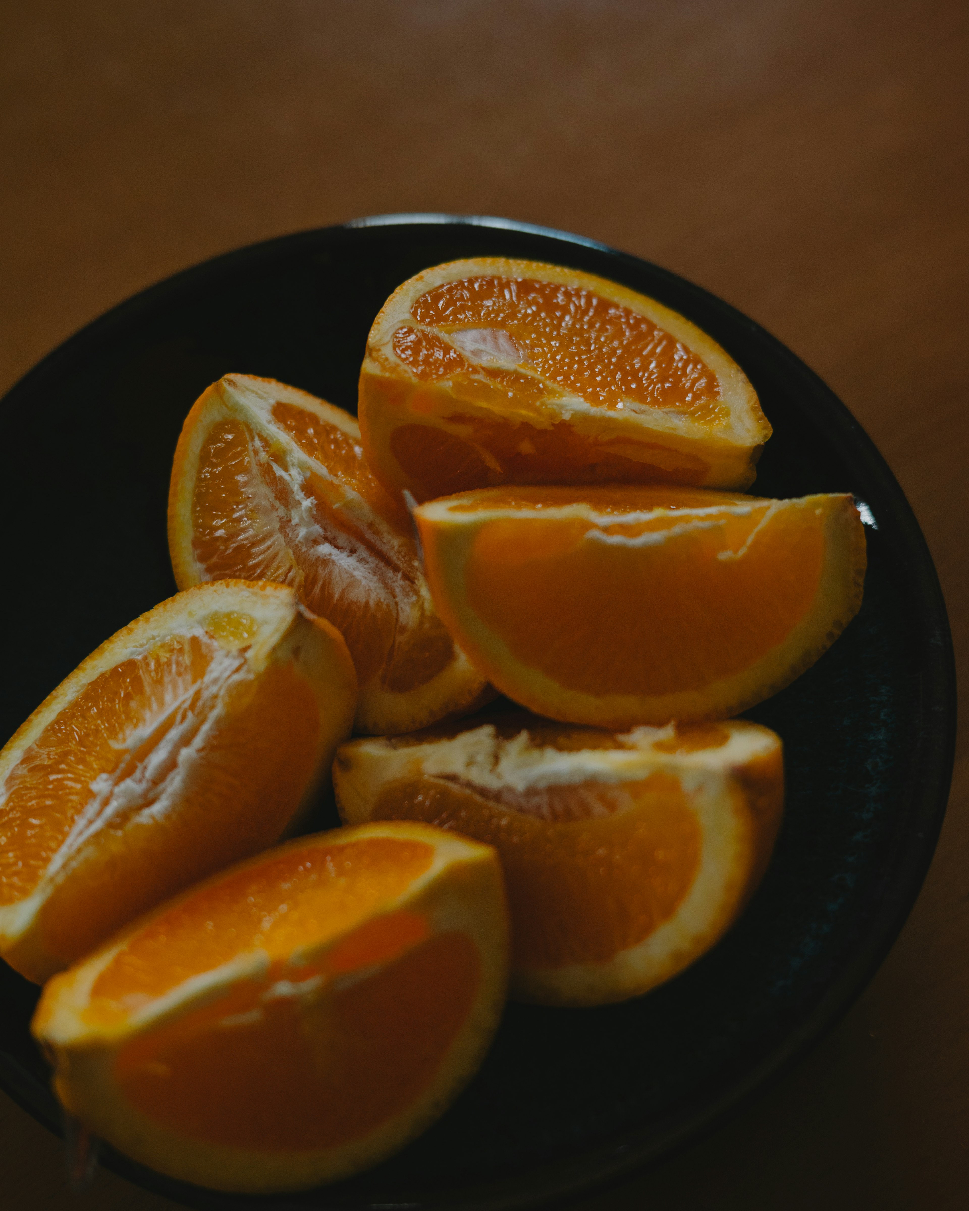 Orangenscheiben in einer schwarzen Schüssel angeordnet