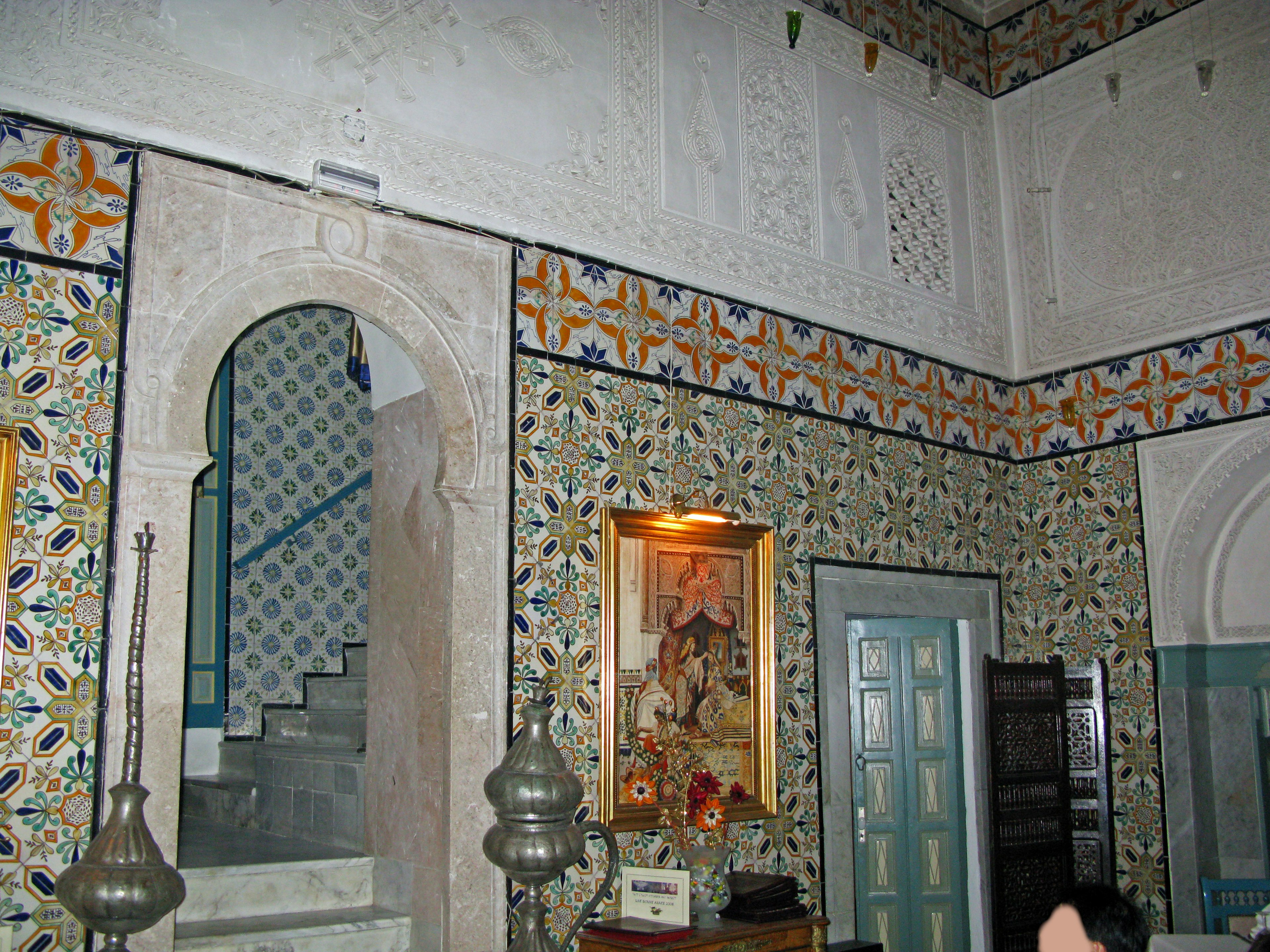 Interior of a room featuring beautiful tiles and decorations with an arched doorway and staircase