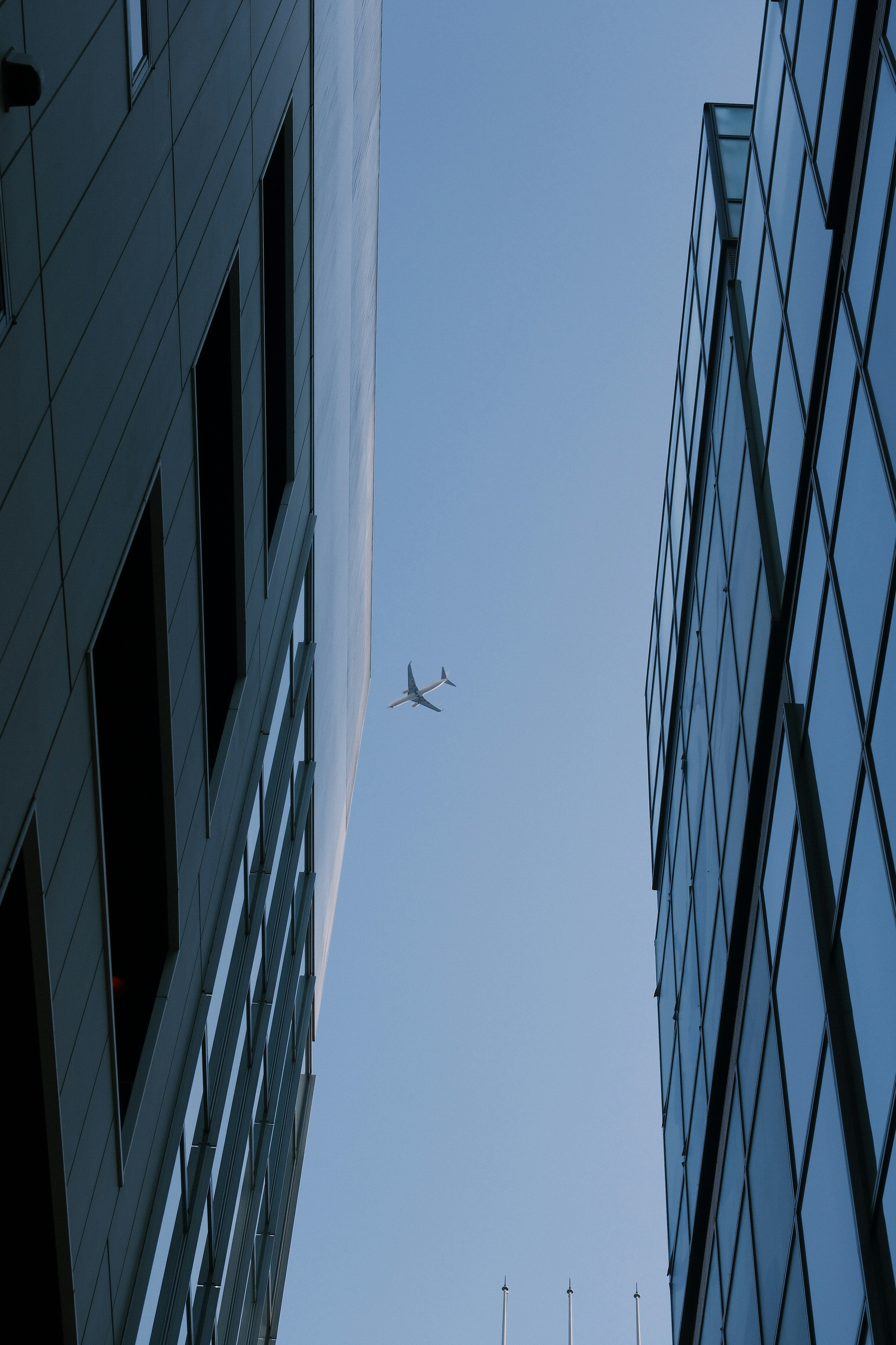 Drone flying between skyscrapers against a blue sky