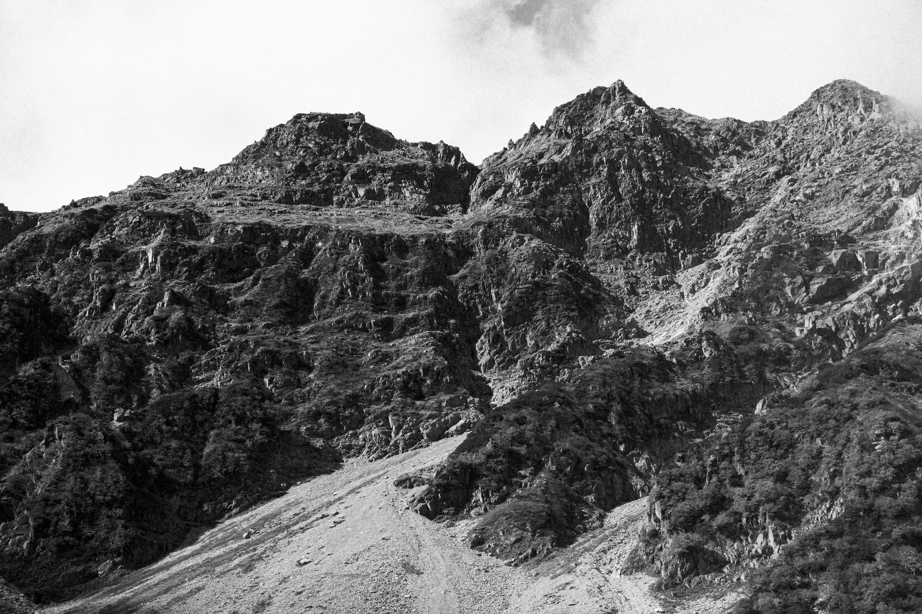 Black and white photo of rugged mountain terrain with rocky texture