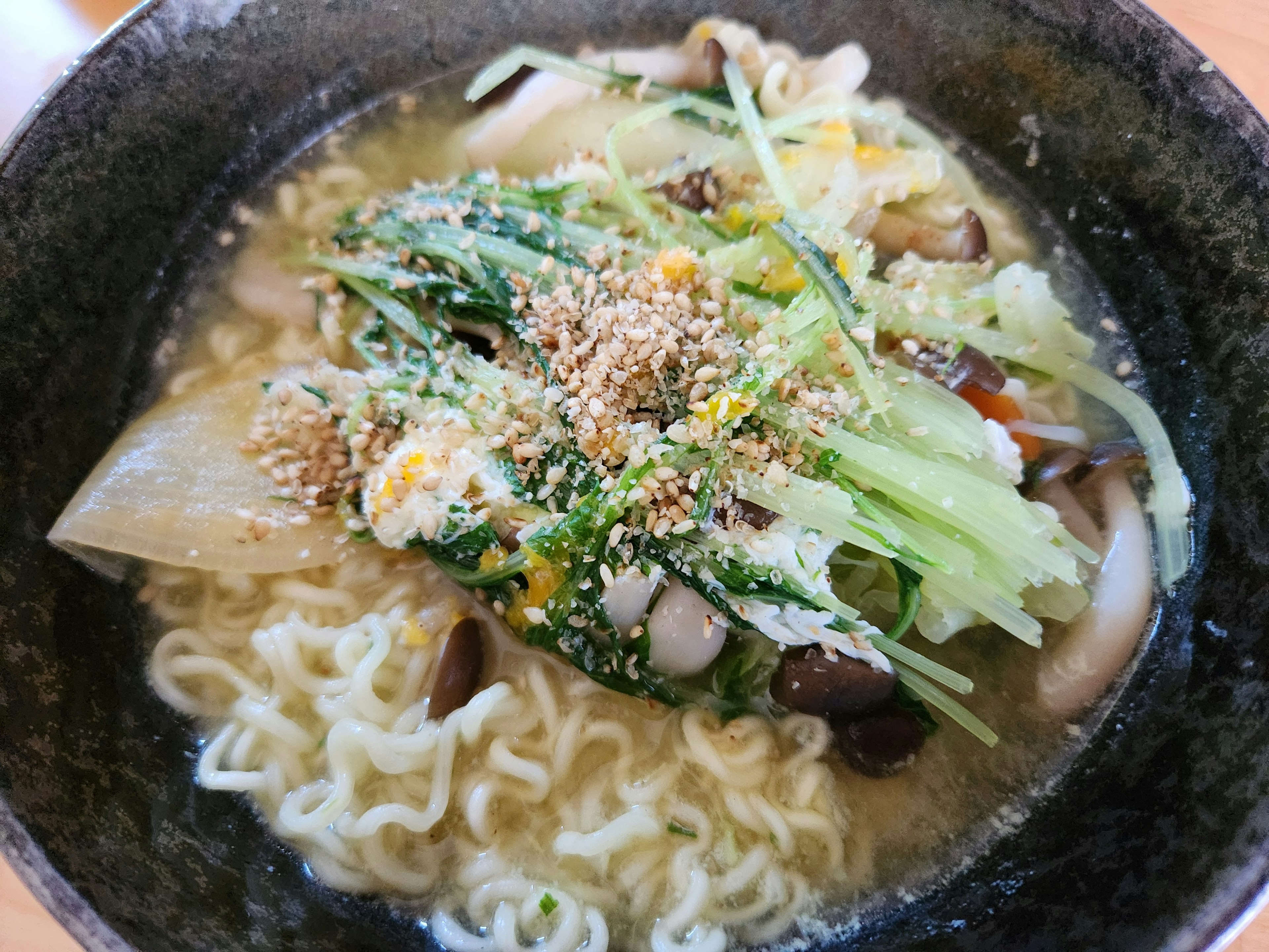 Bowl of ramen with fresh vegetables and sesame topping