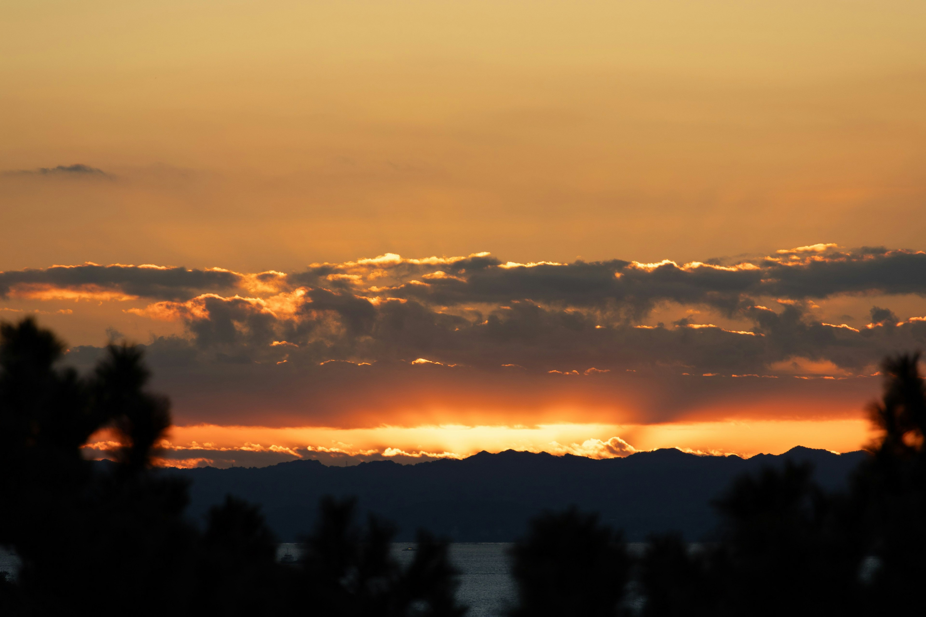 夕焼けの美しい風景 山々のシルエットとオレンジ色の空
