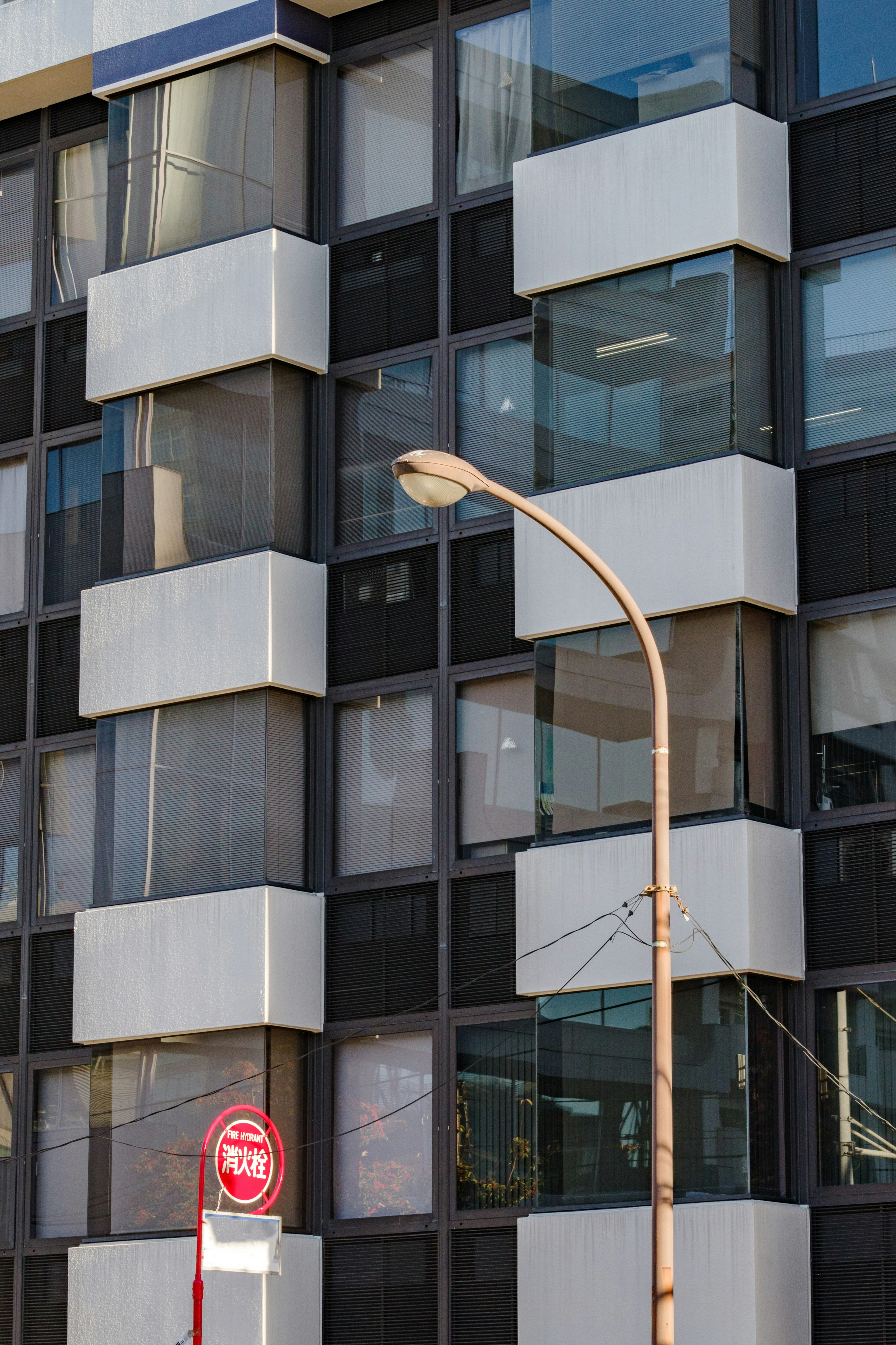 Fachada de edificio moderno con diseño en blanco y negro y farola