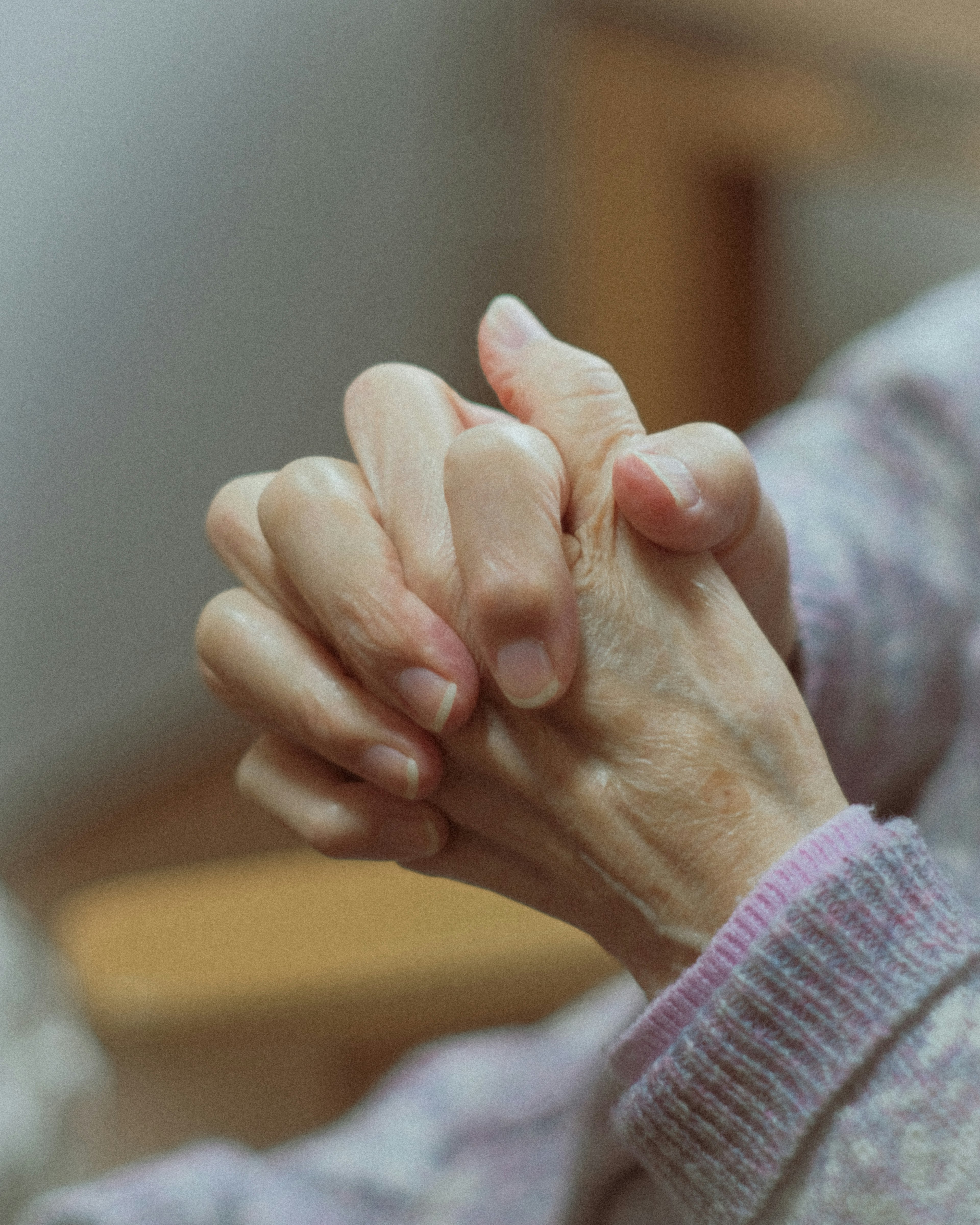 Close-up of elderly hands clasped together