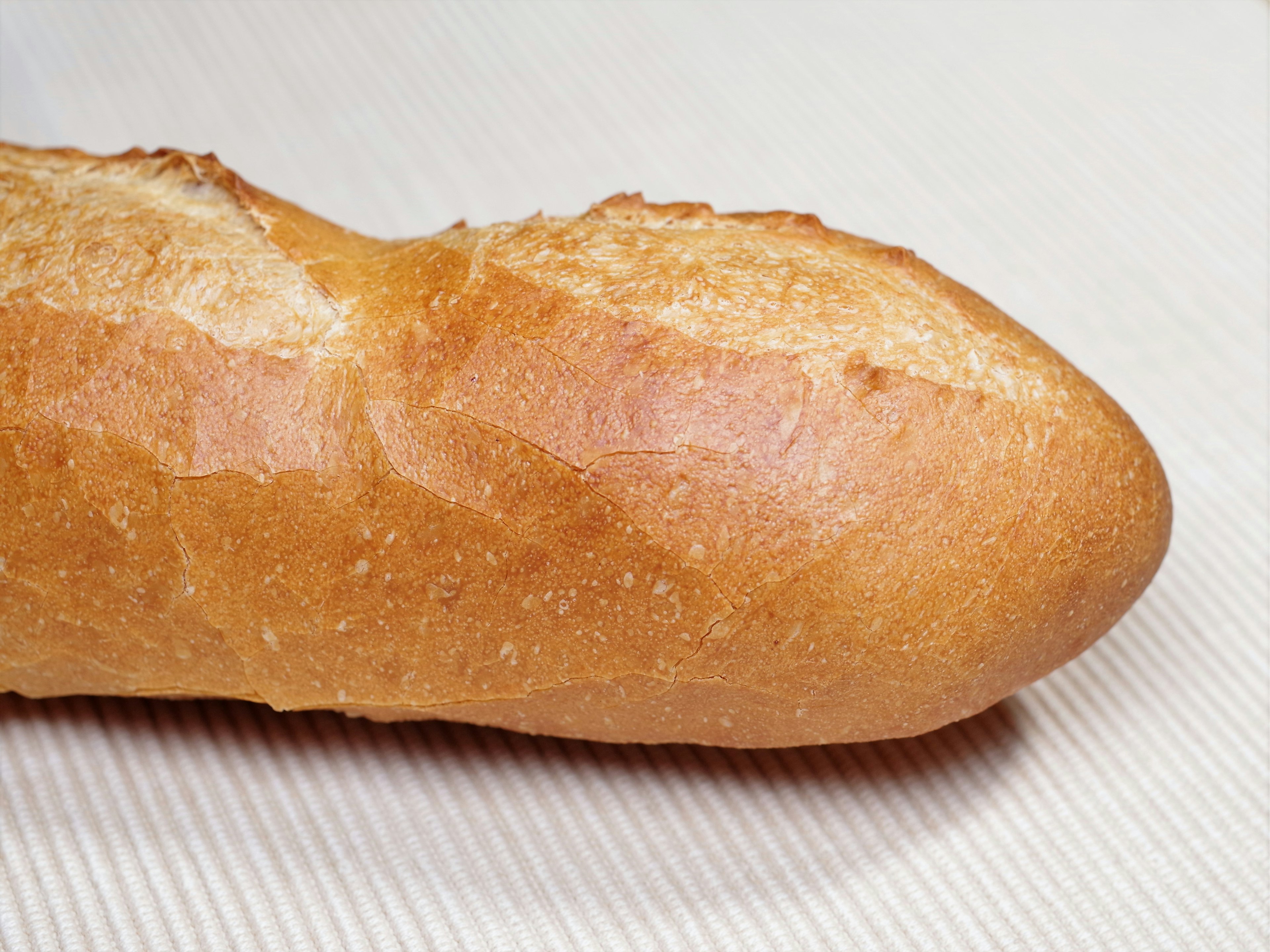 A freshly baked baguette displayed on a light background