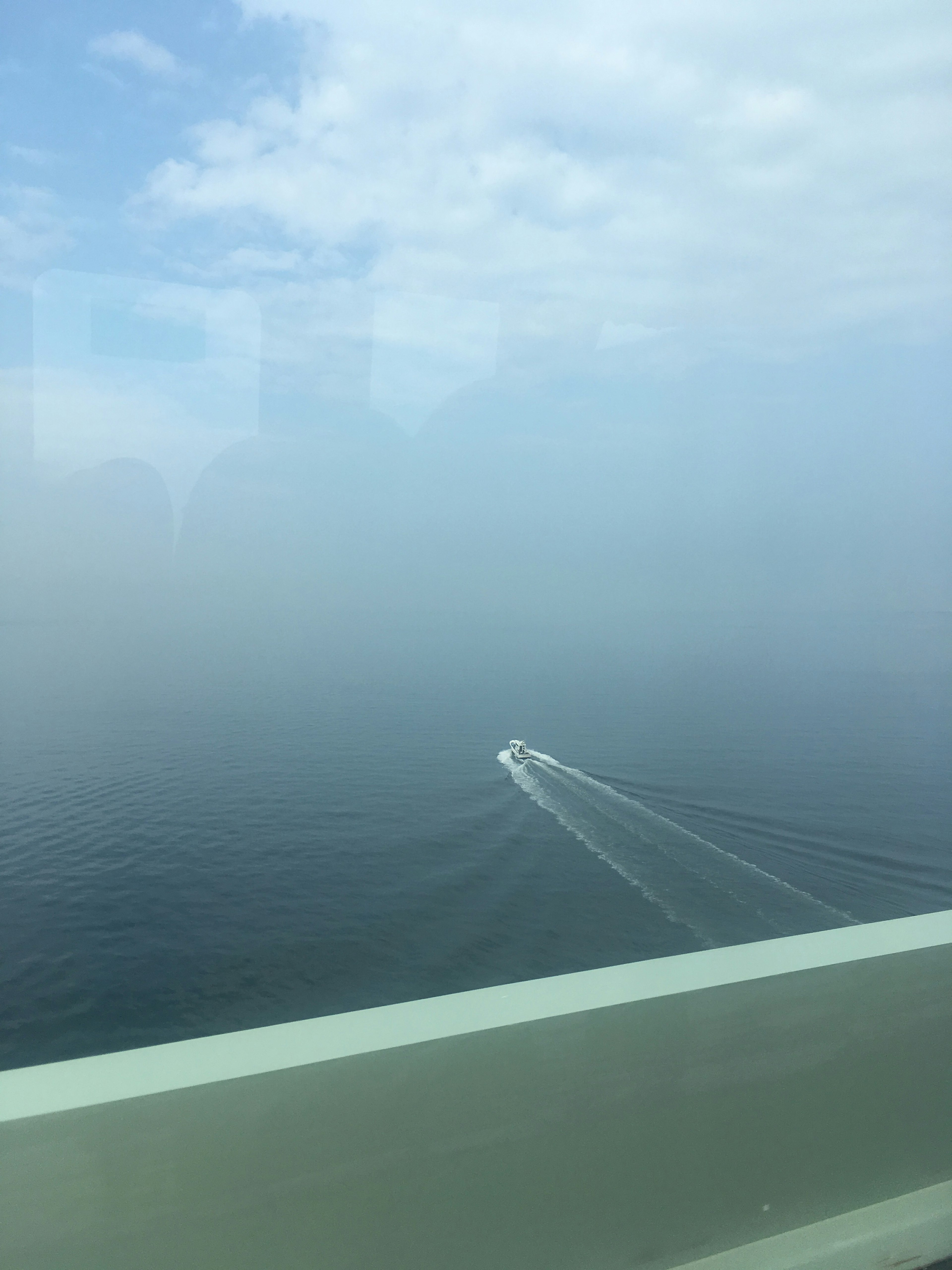 霧の中を進むボートと広がる海の風景