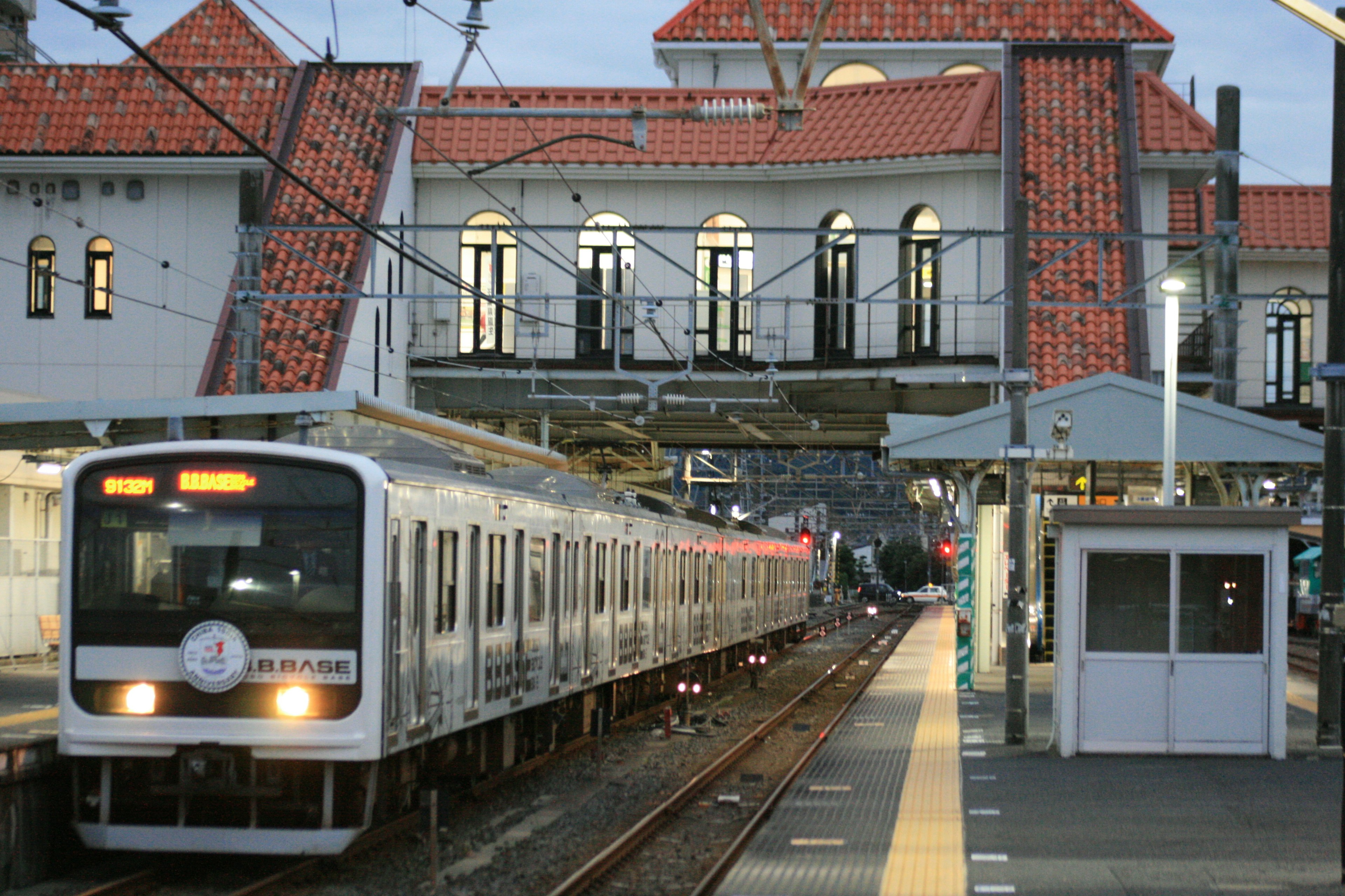 Train stopped at a station with a historical building in the background