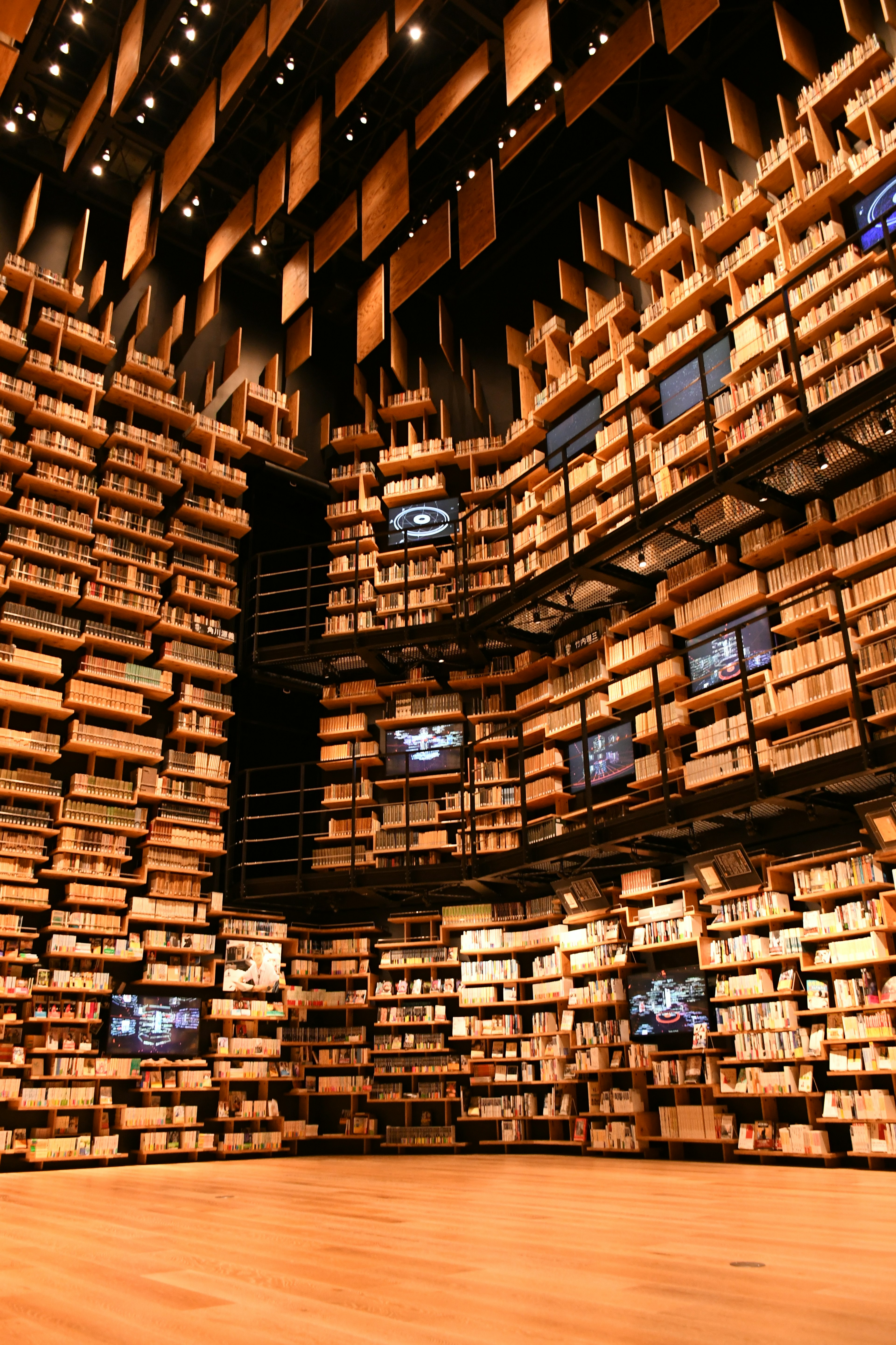 Interno di una biblioteca moderna con scaffali in legno e schermi