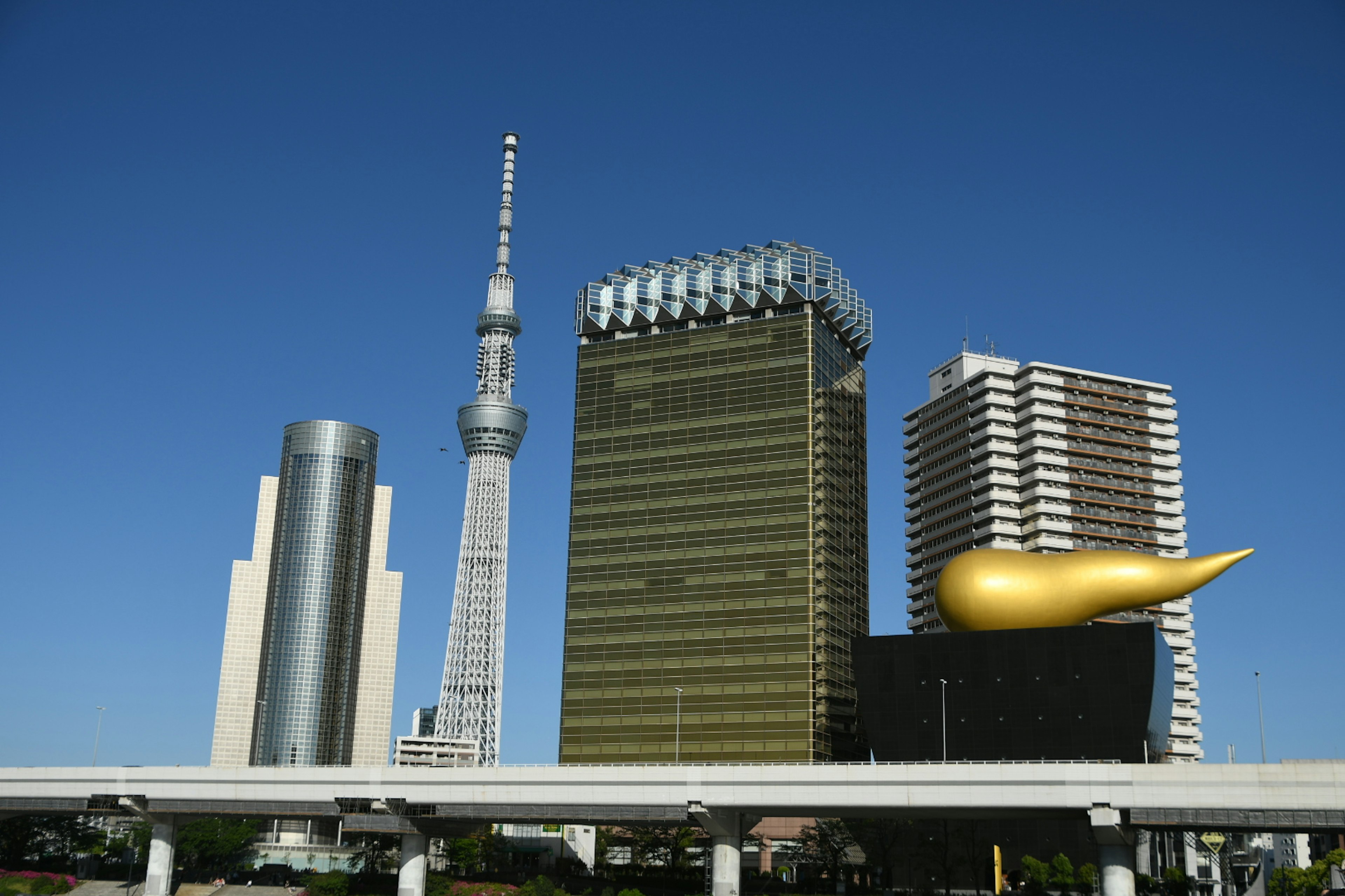 東京スカイツリーとアサヒビール本社の金色の炎のオブジェが見える都市の景観