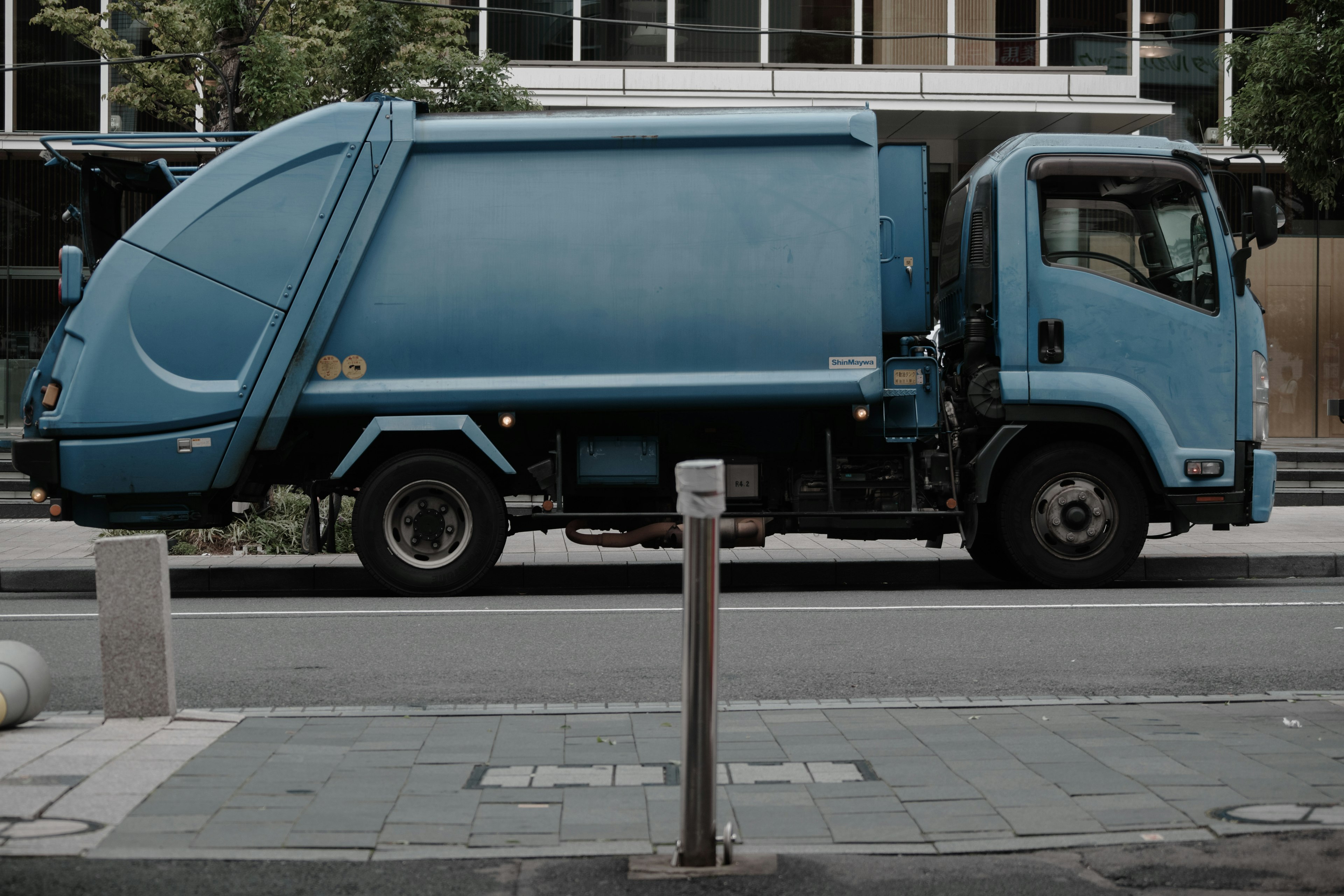 Truk sampah biru diparkir di jalan