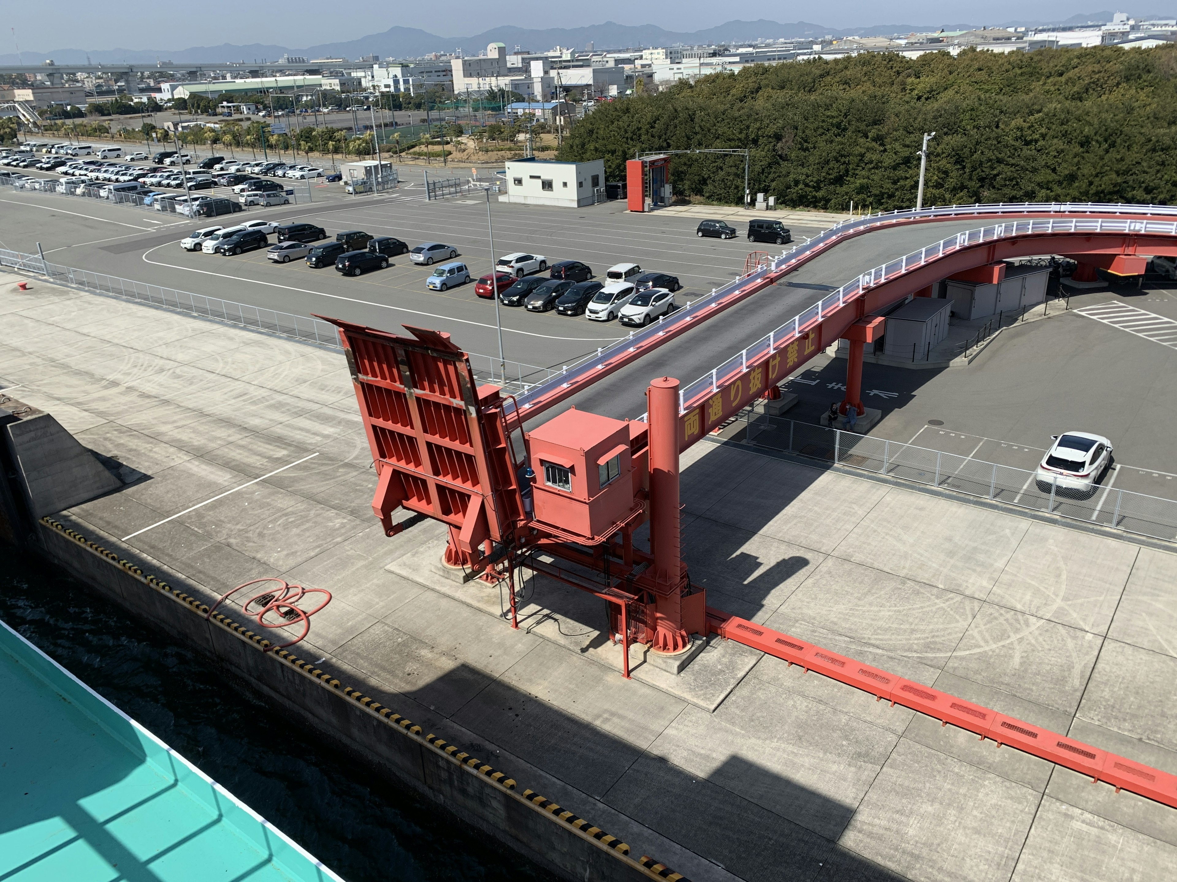 View of a port with a red bridge and parking lot