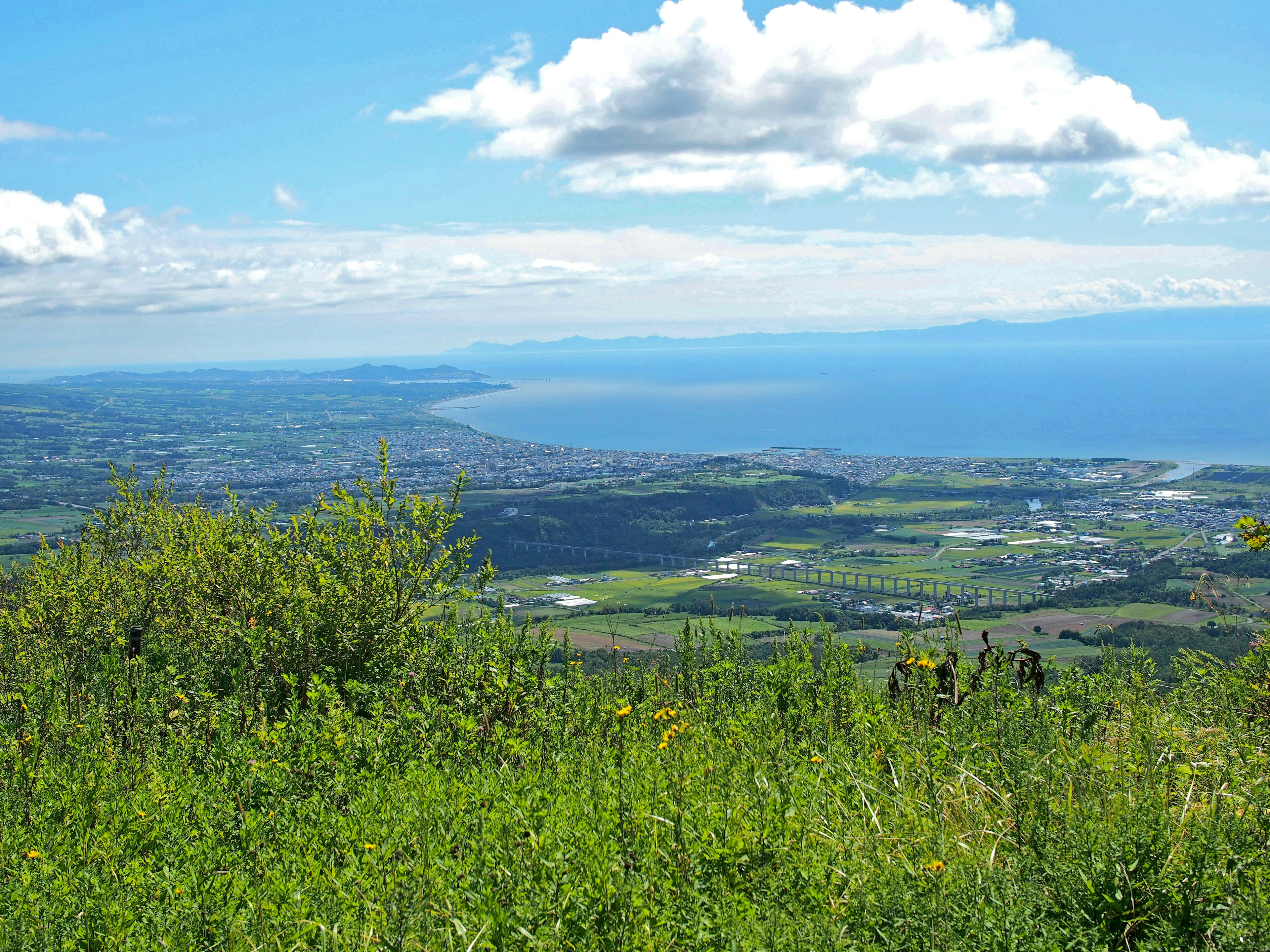 Vue panoramique de la mer bleue et des collines vertes