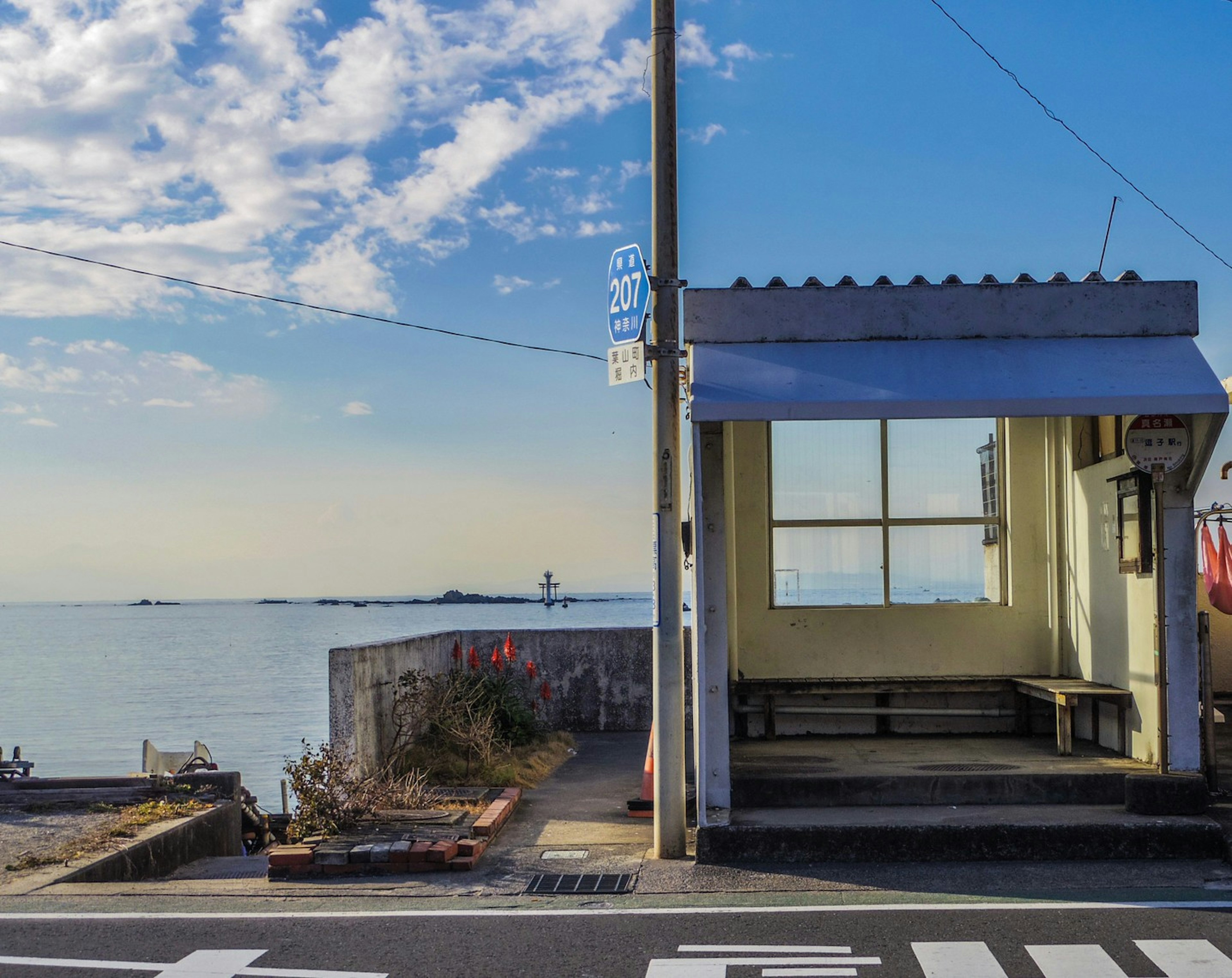 海の近くのバス停と澄んだ空